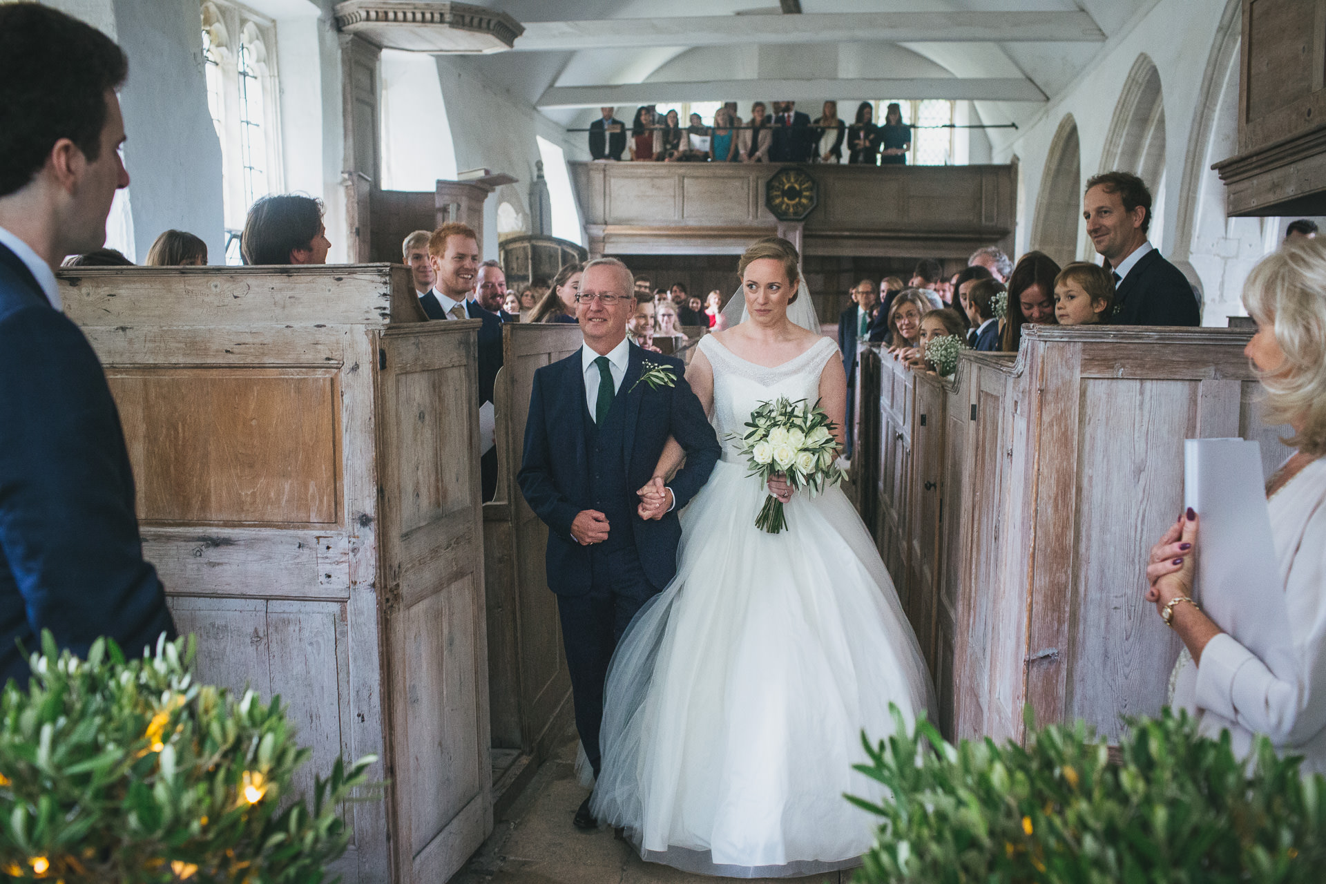 Bride and her father walking up the aisle at humanist wedding ceremony in a disused church