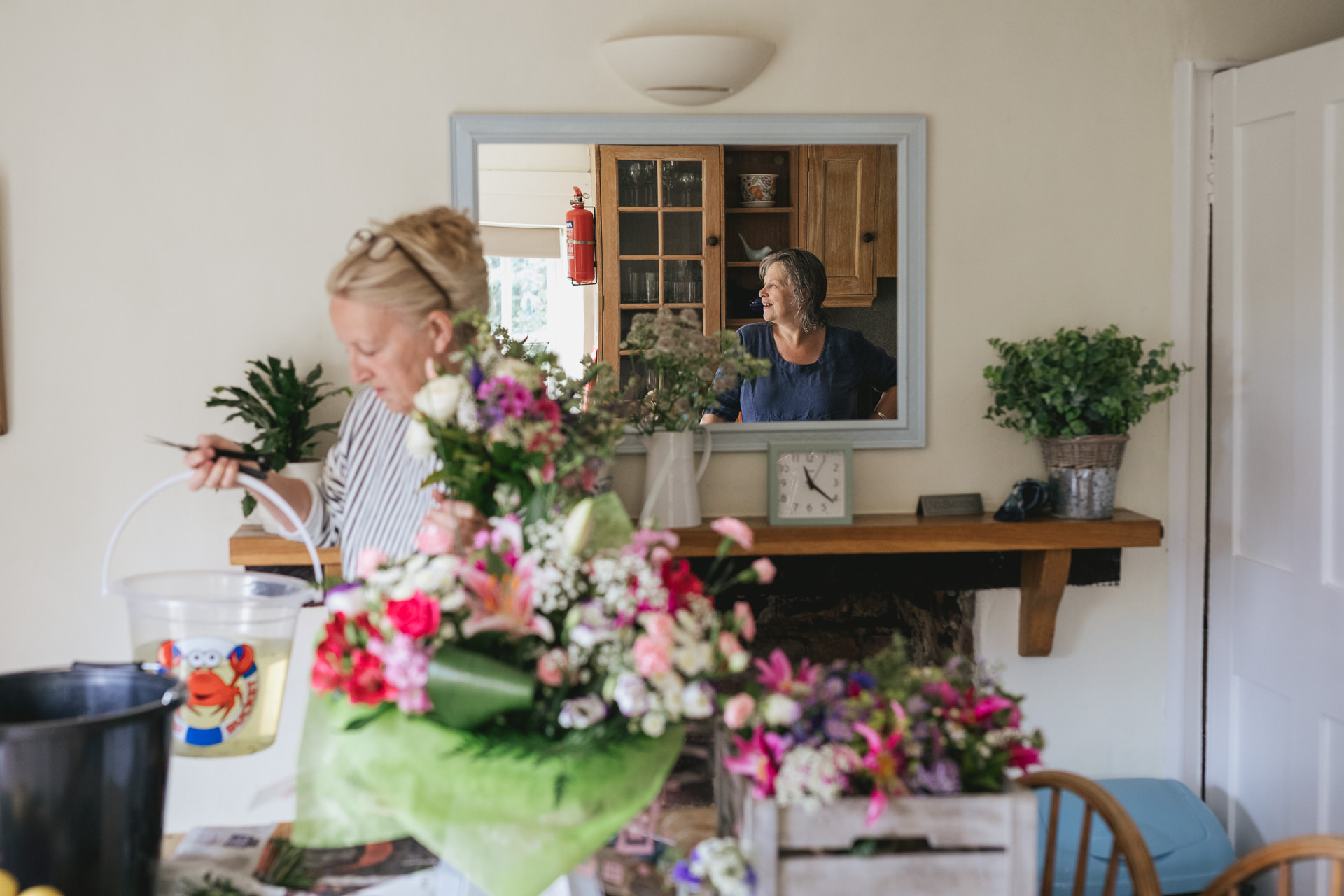 Florist arranging flowers with woman reflected in mirror