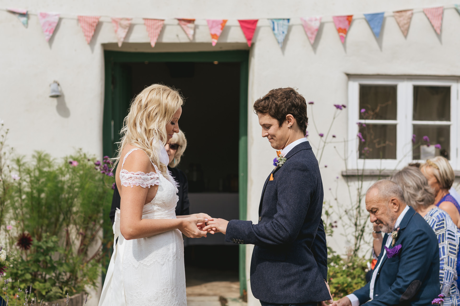 Bride and groom exchanging rings outside River Cottage farmhouse