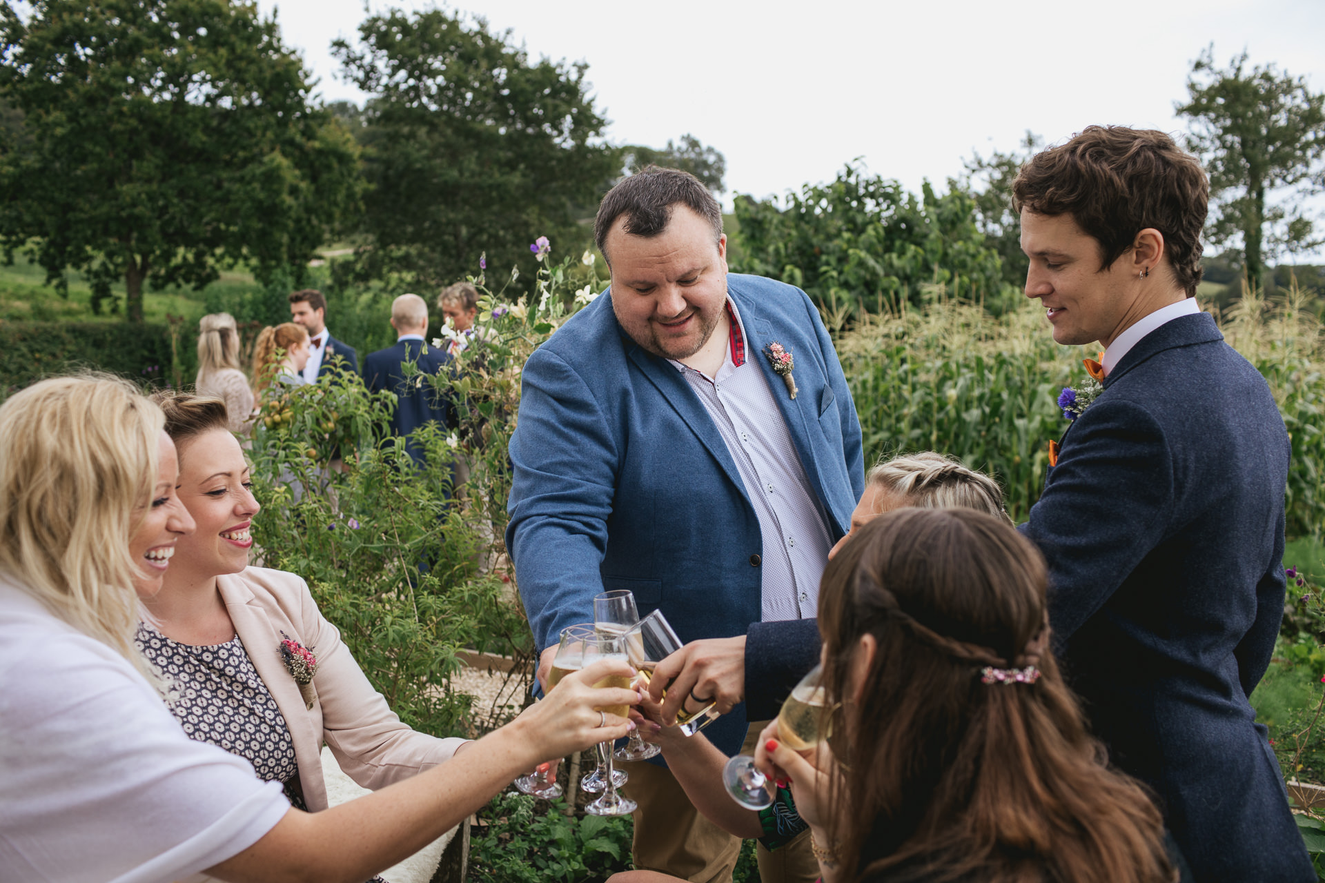 Wedding guests clinking glasses together in the kitchen garden