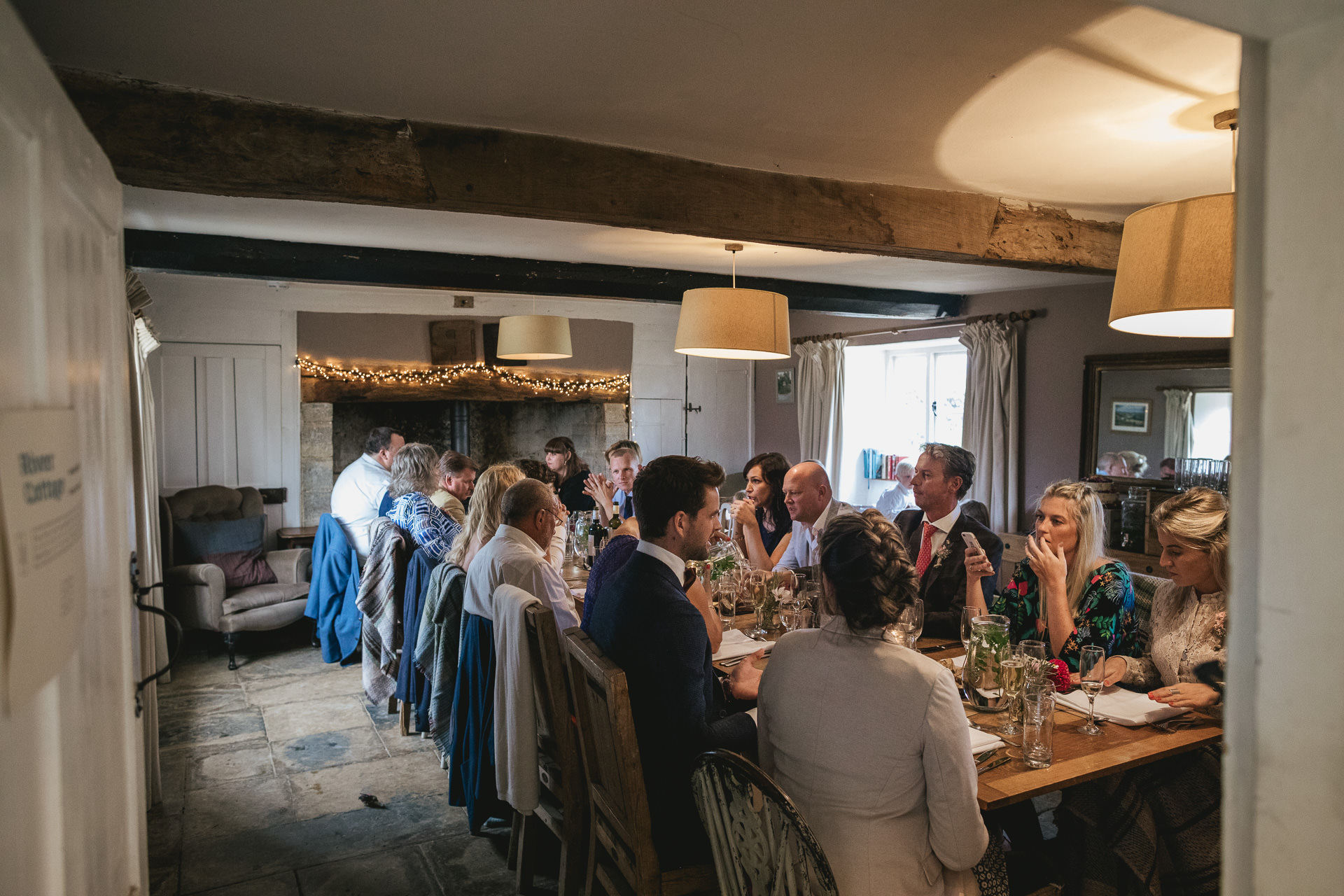 Wedding guests eating in the farmhouse at River Cottage