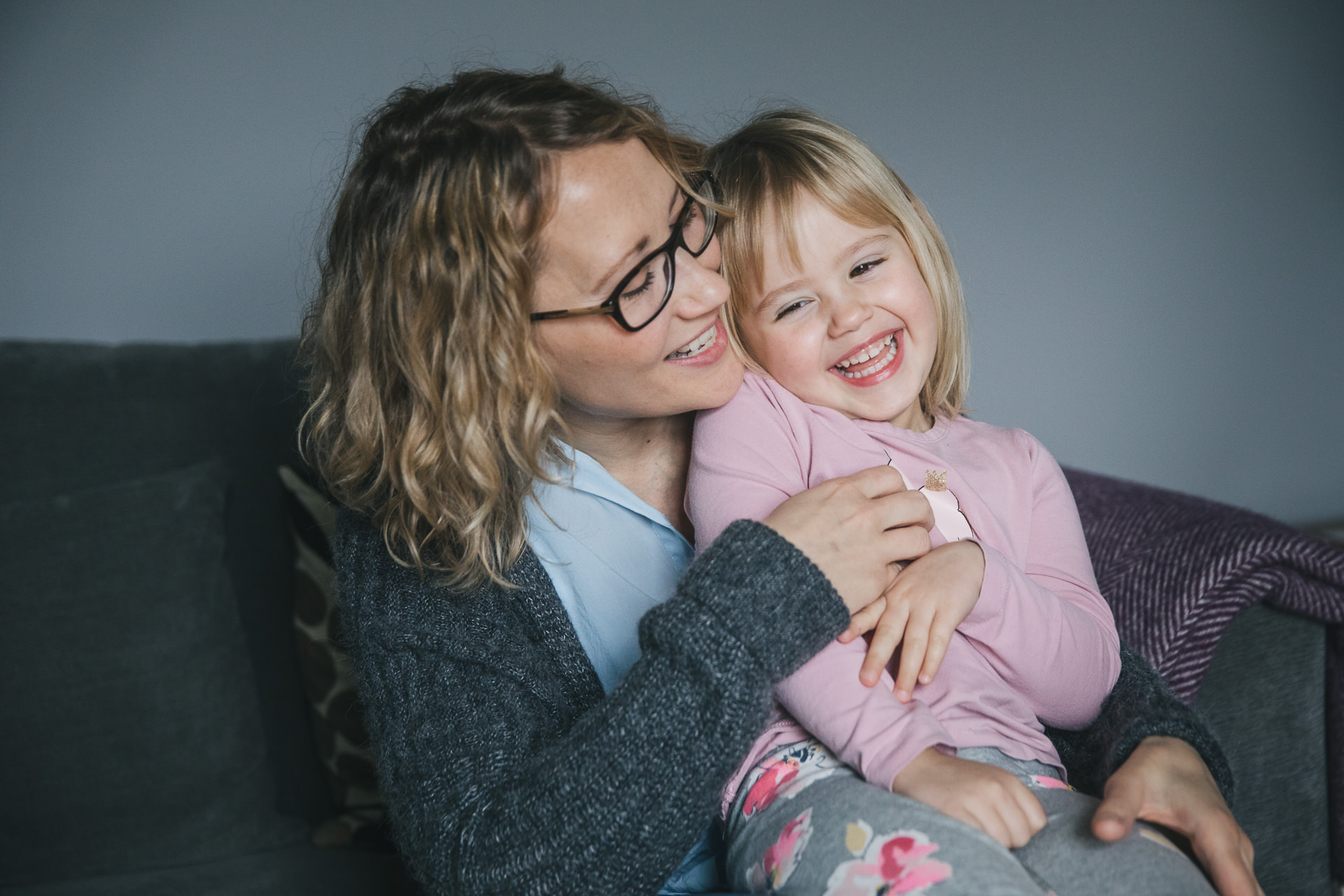 Relaxed family photo of a mother and daughter laughing together