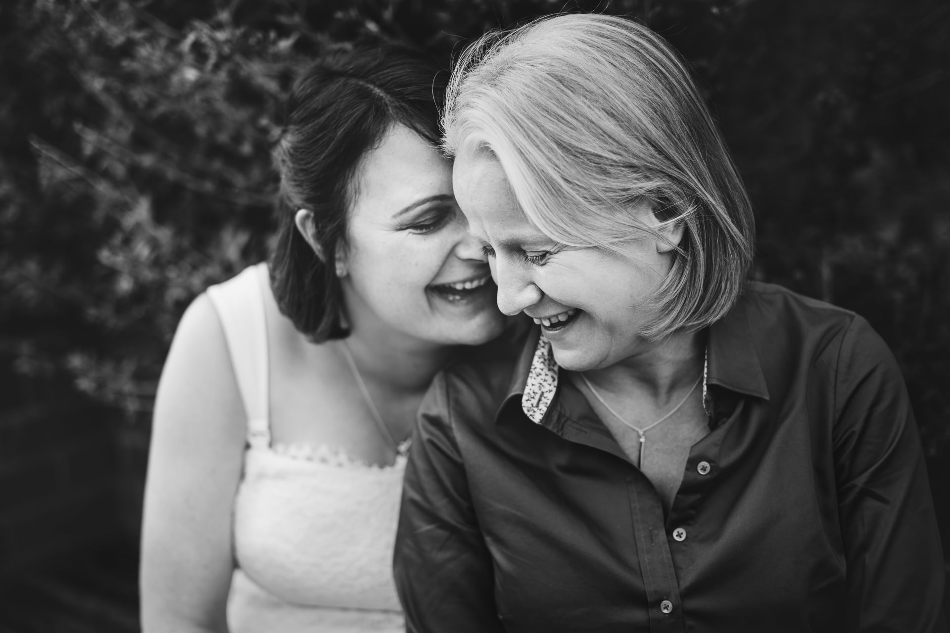 Bride and bride cuddling and laughing together