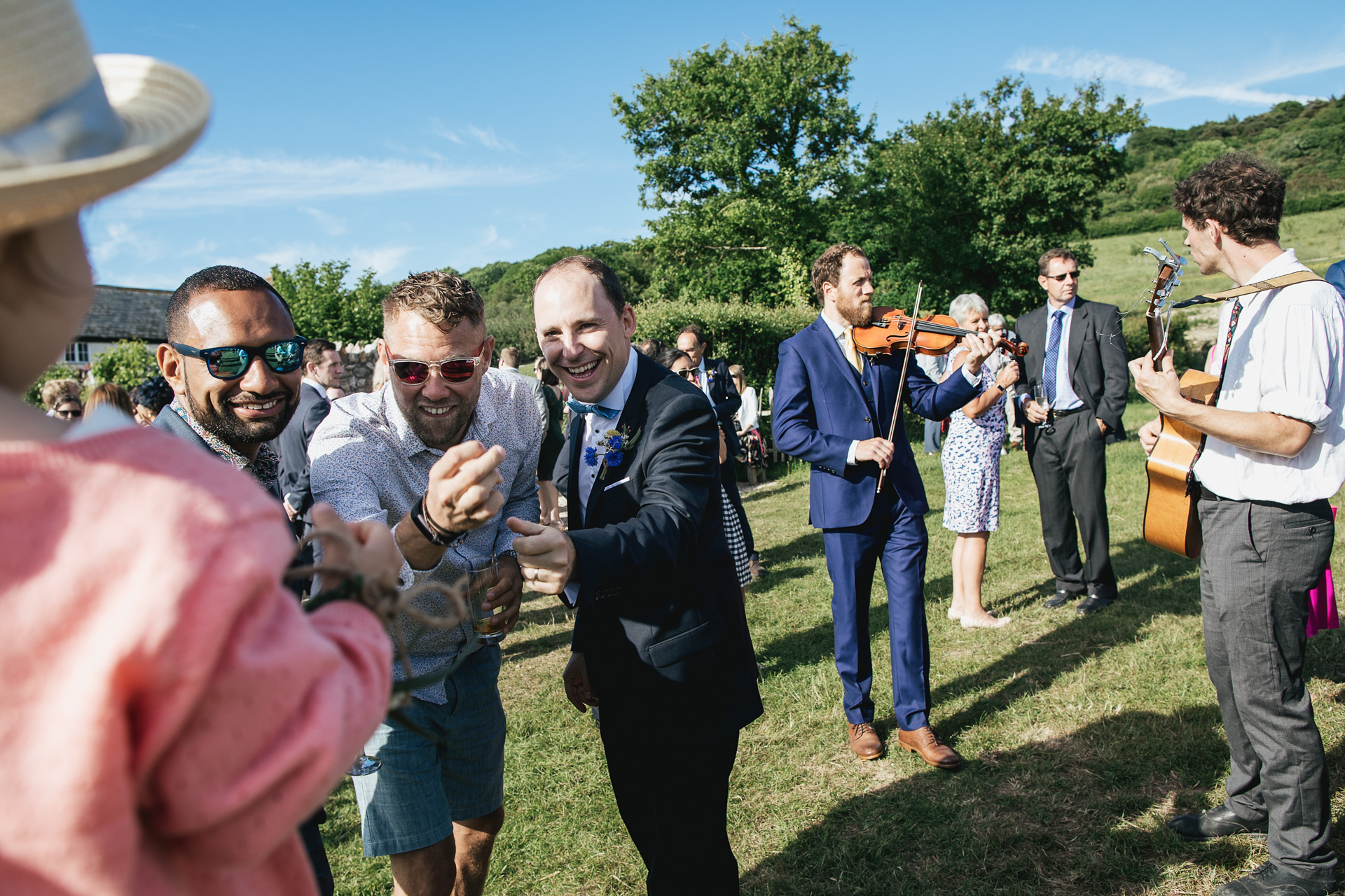 Wedding guests laughing in a field