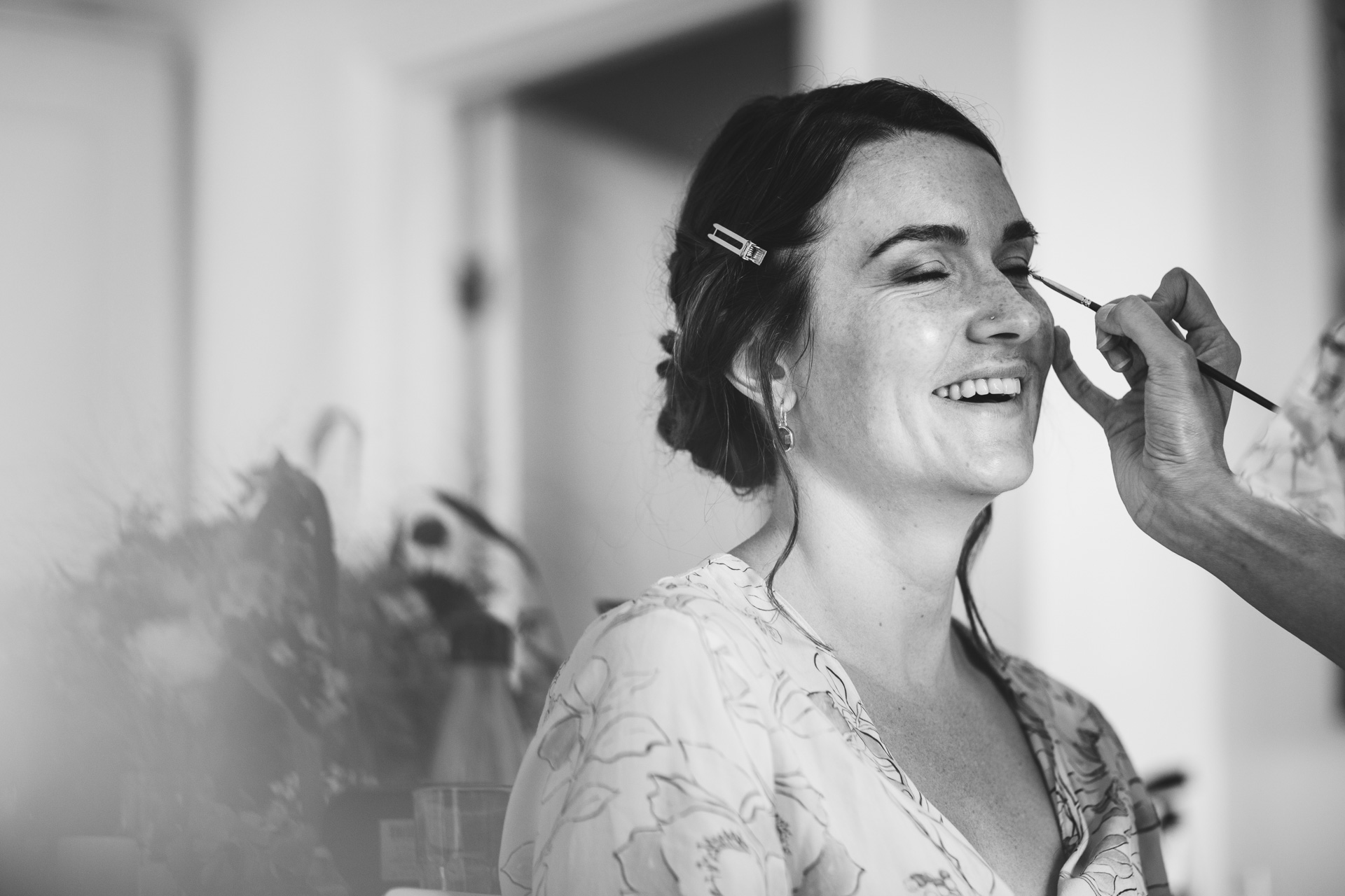 Bride smiling and having make up done