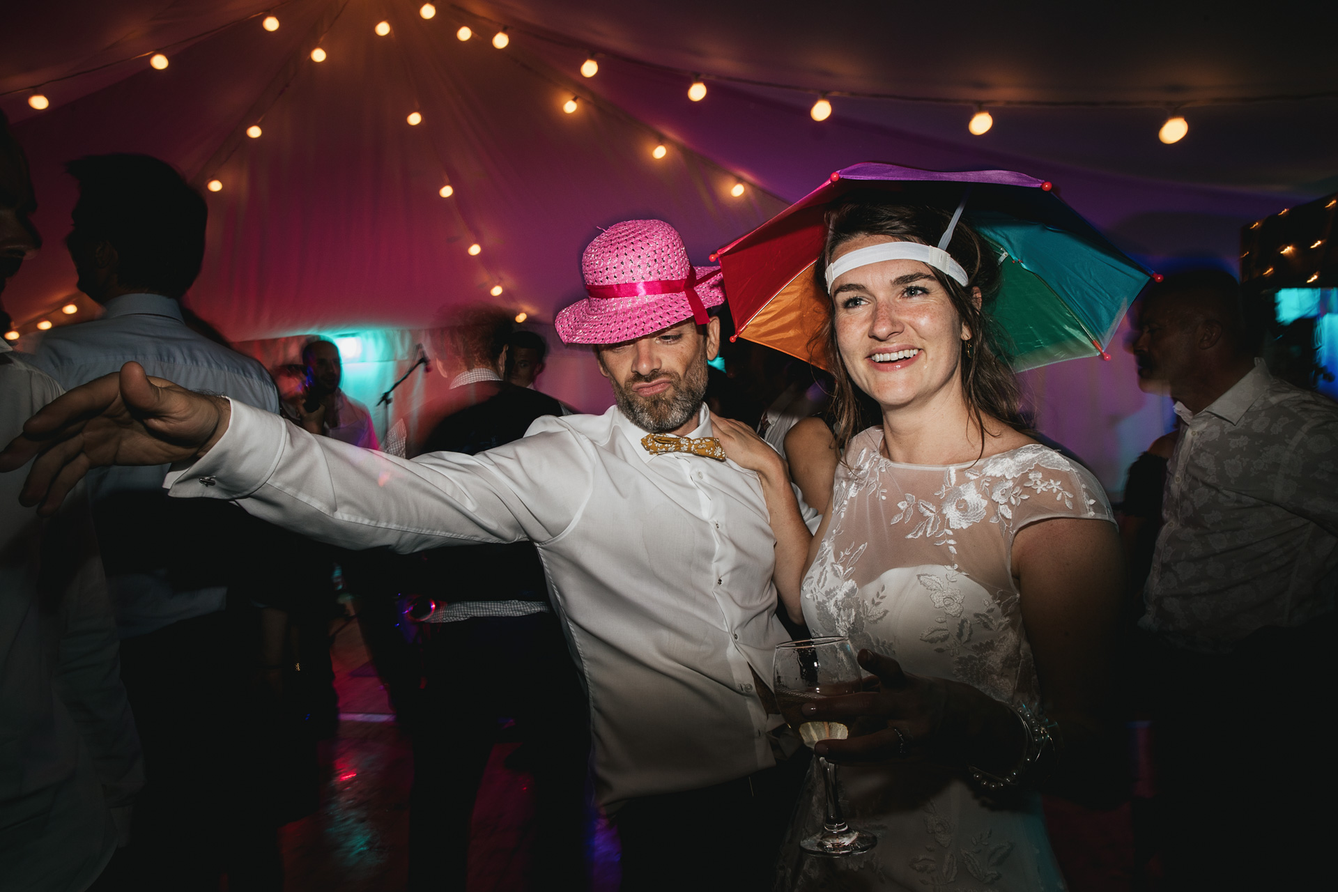 Bride and groom dancing with silly hats