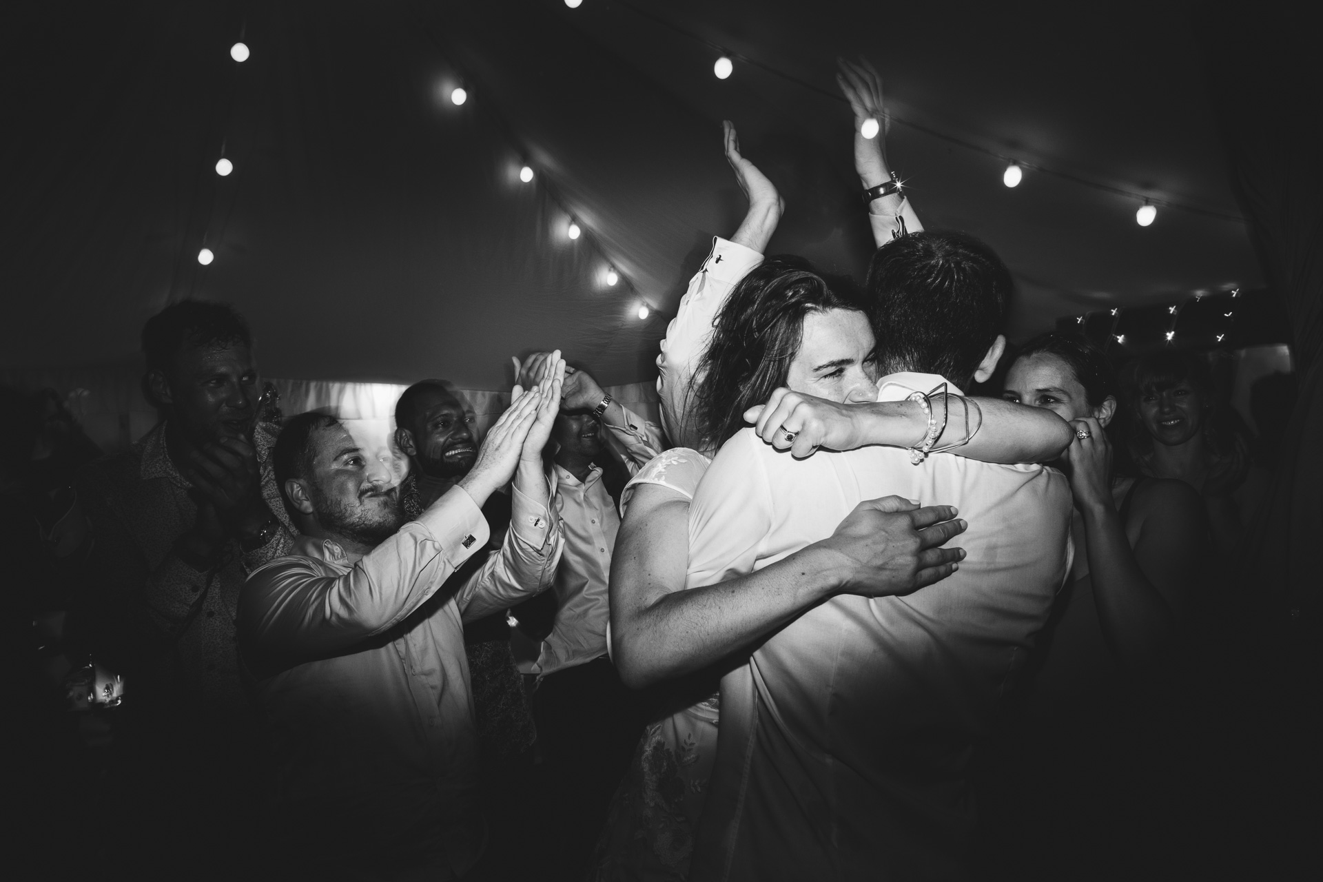 Bride and groom hugging on dance floor 
