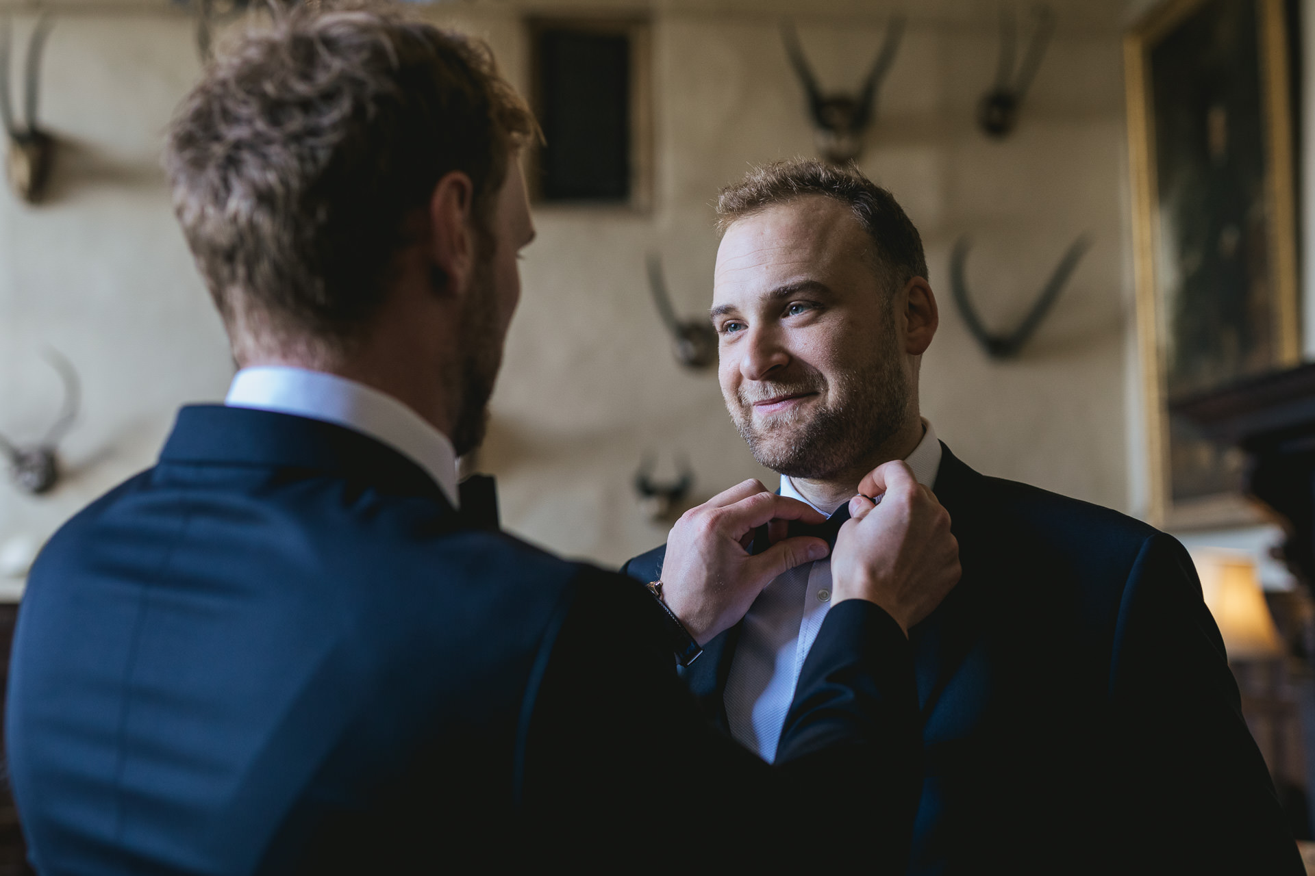 Groom to be having his tie adjusted