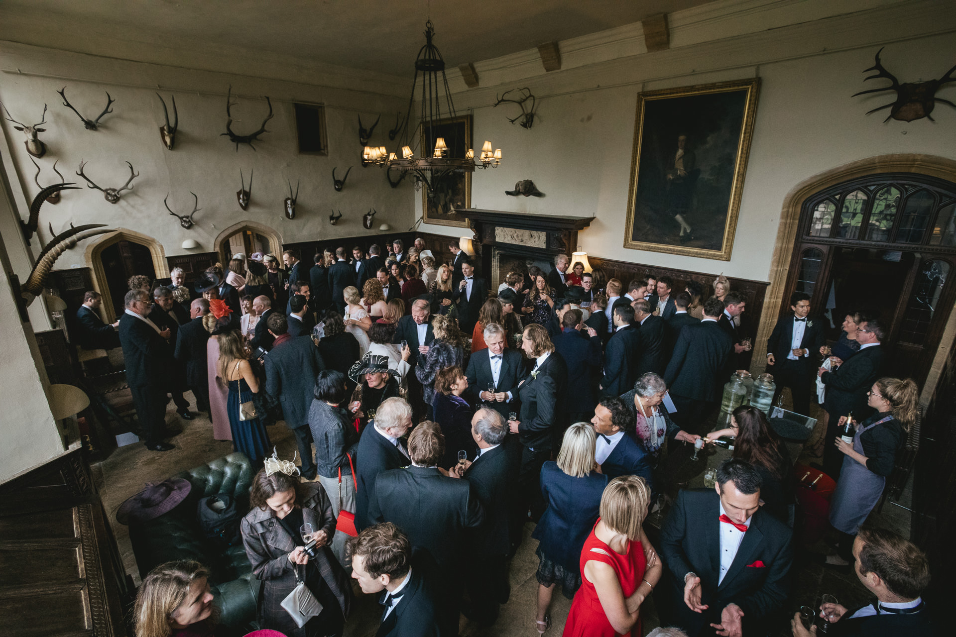 Wedding guests celebrating in entrance hallway at Brympton House