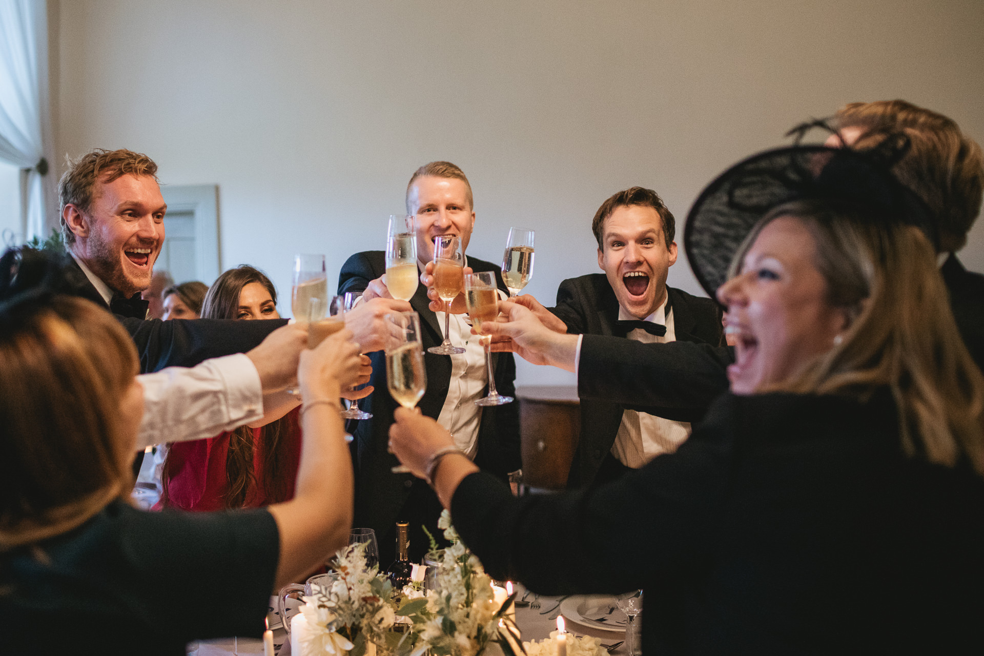 Wedding guests around a table toasting with glasses
