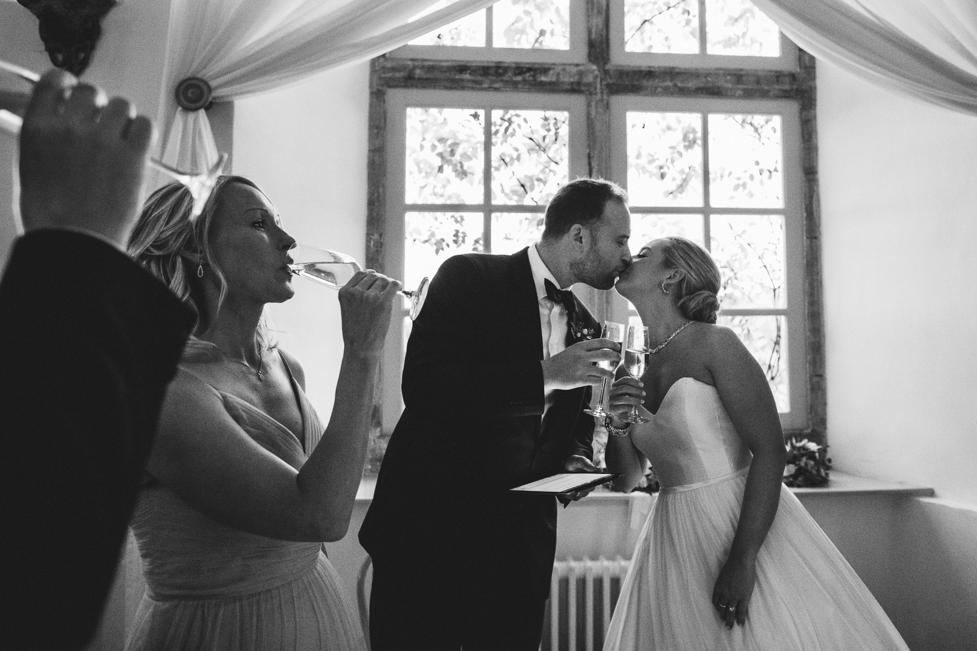 Bride and groom kissing during speeches toast