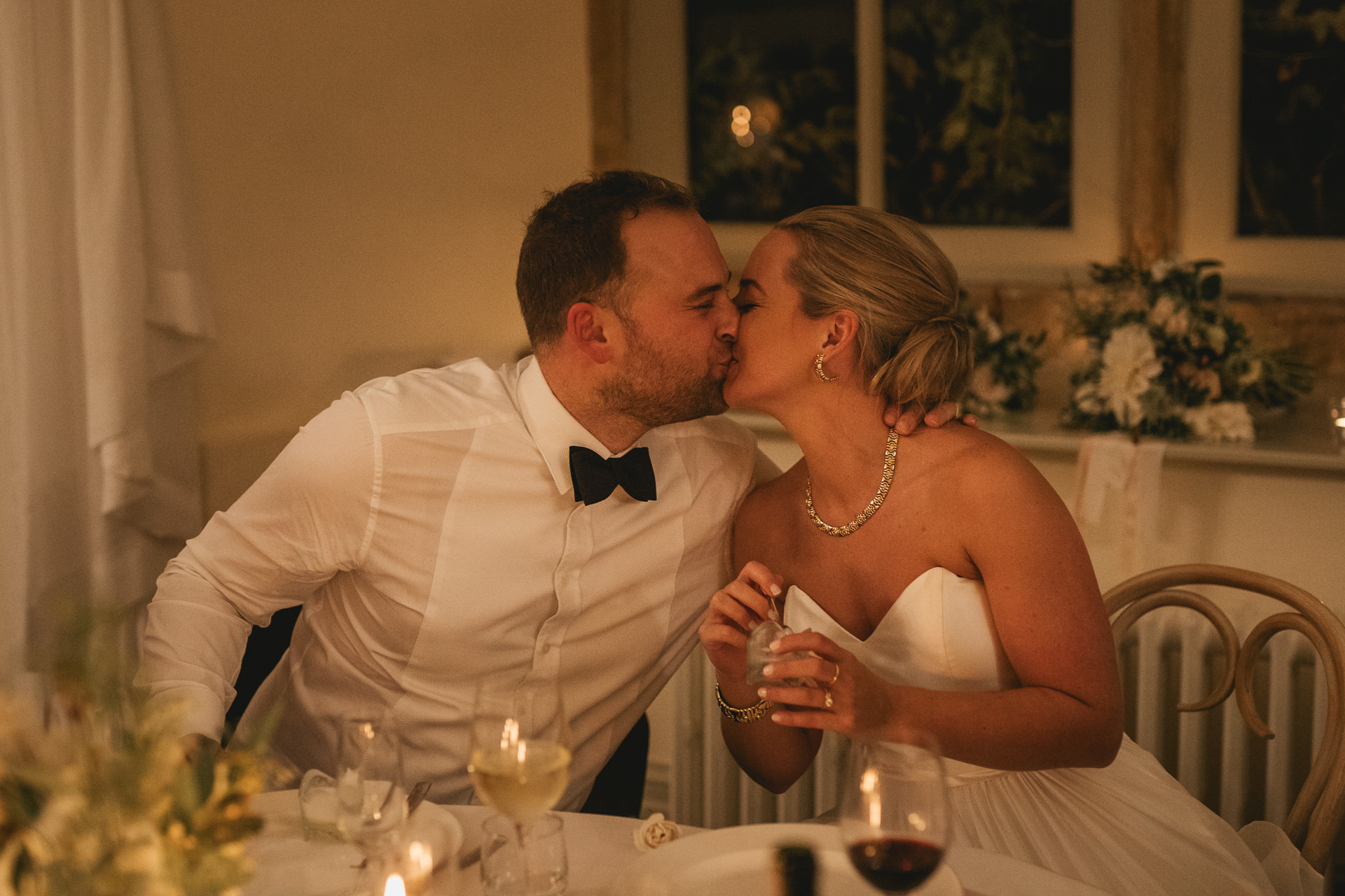 Bride and groom kissing at the table