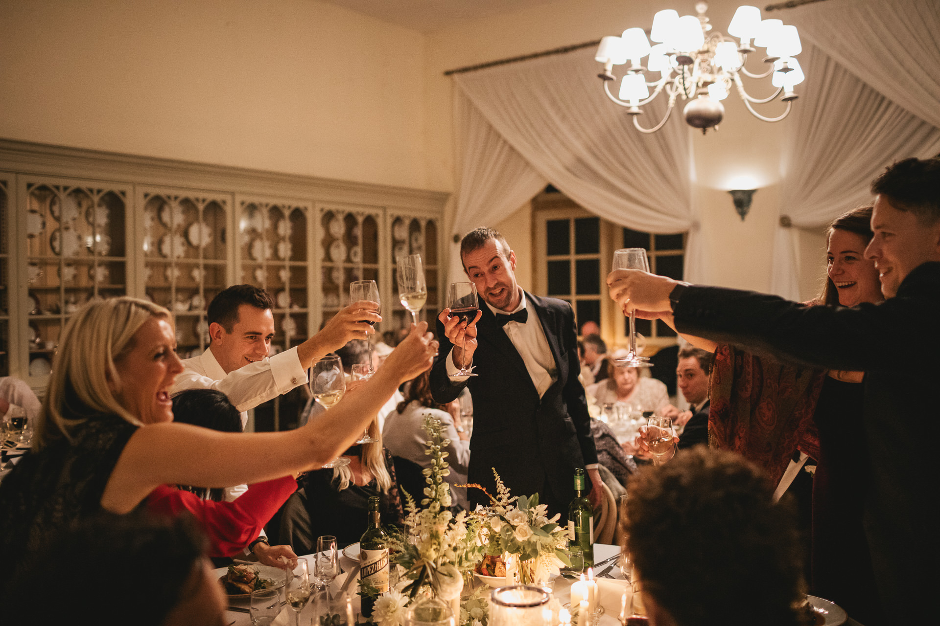 Wedding guests around a table toasting with glasses