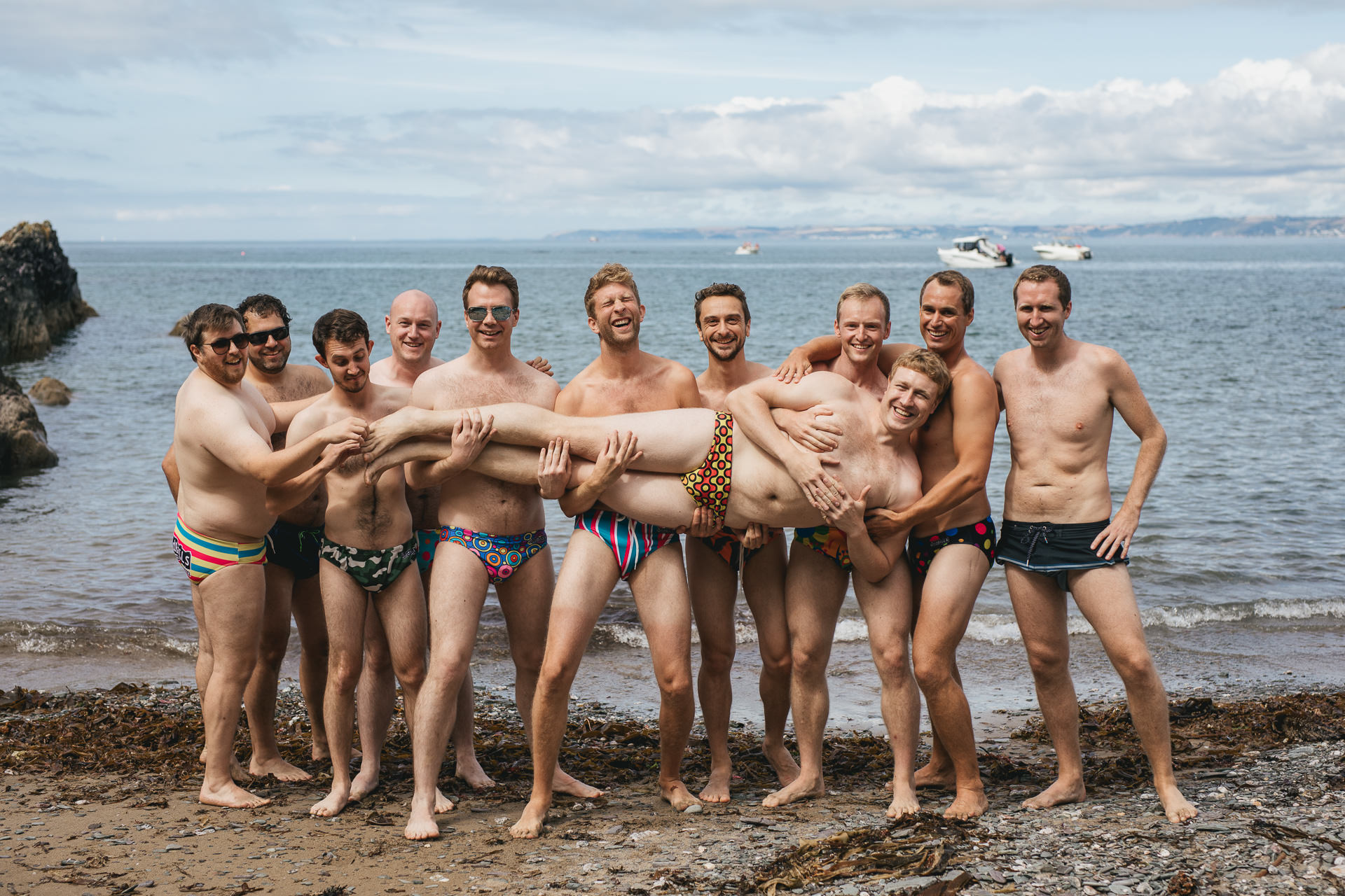 Groom and friends on the beach in swimming trunks