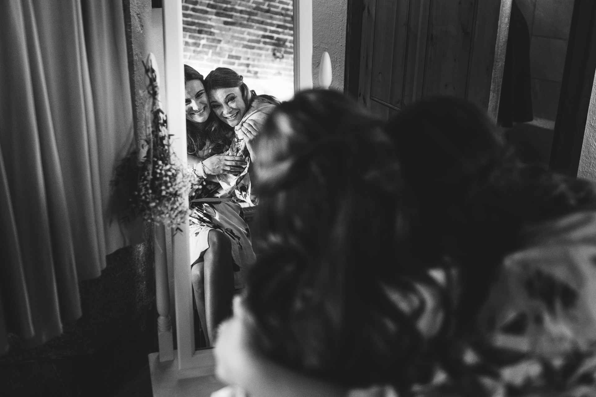 Bride and sister cuddling in a mirror