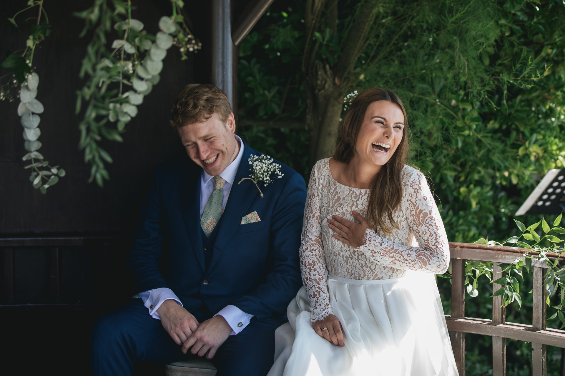Bride and groom laughing during outdoor wedding ceremony
