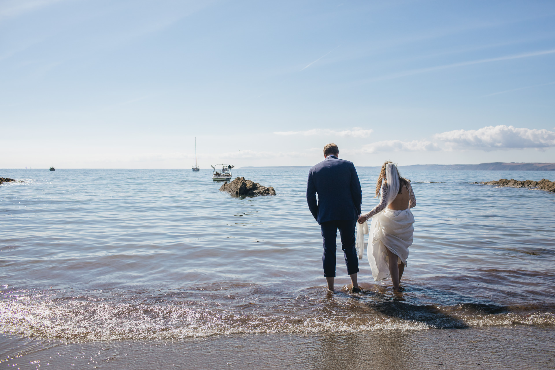 Bride and groom paddling in the sea