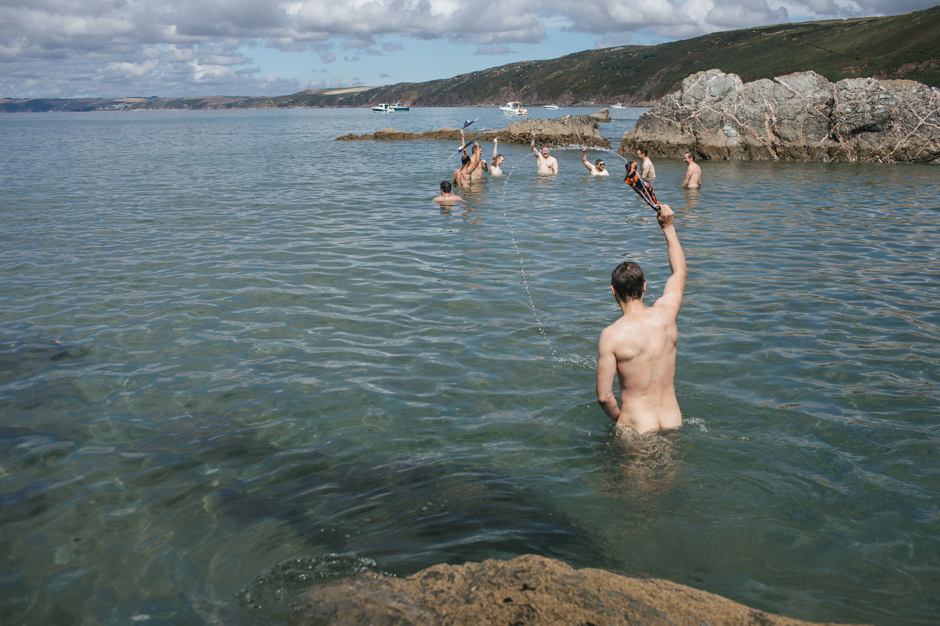 Men in the sea waving trunks in the air