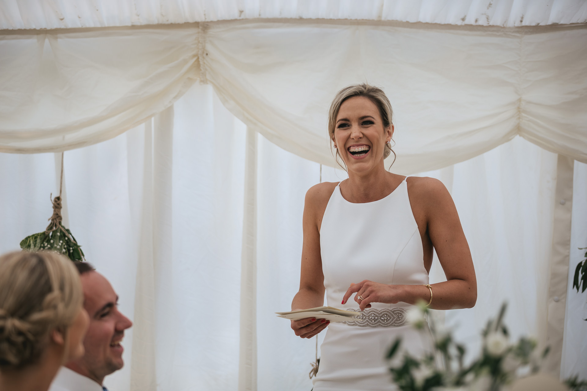 Bride laughing and giving wedding speech