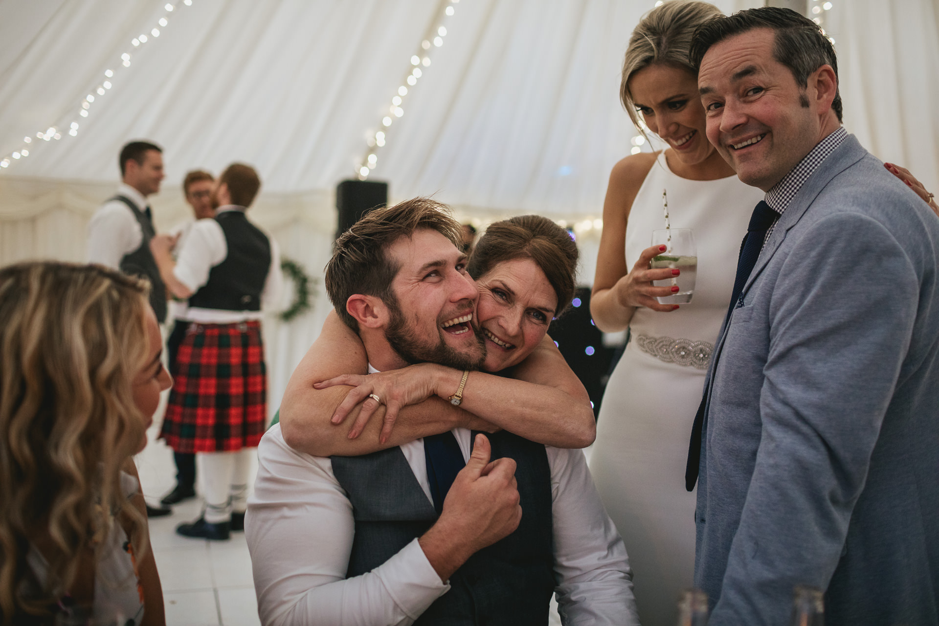 Bride laughing with family in a marquee