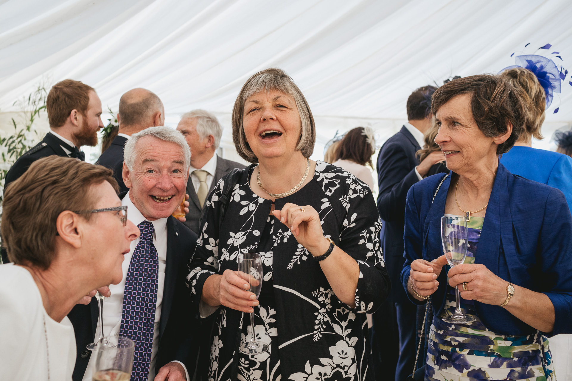 Guests laughing inside a marquee