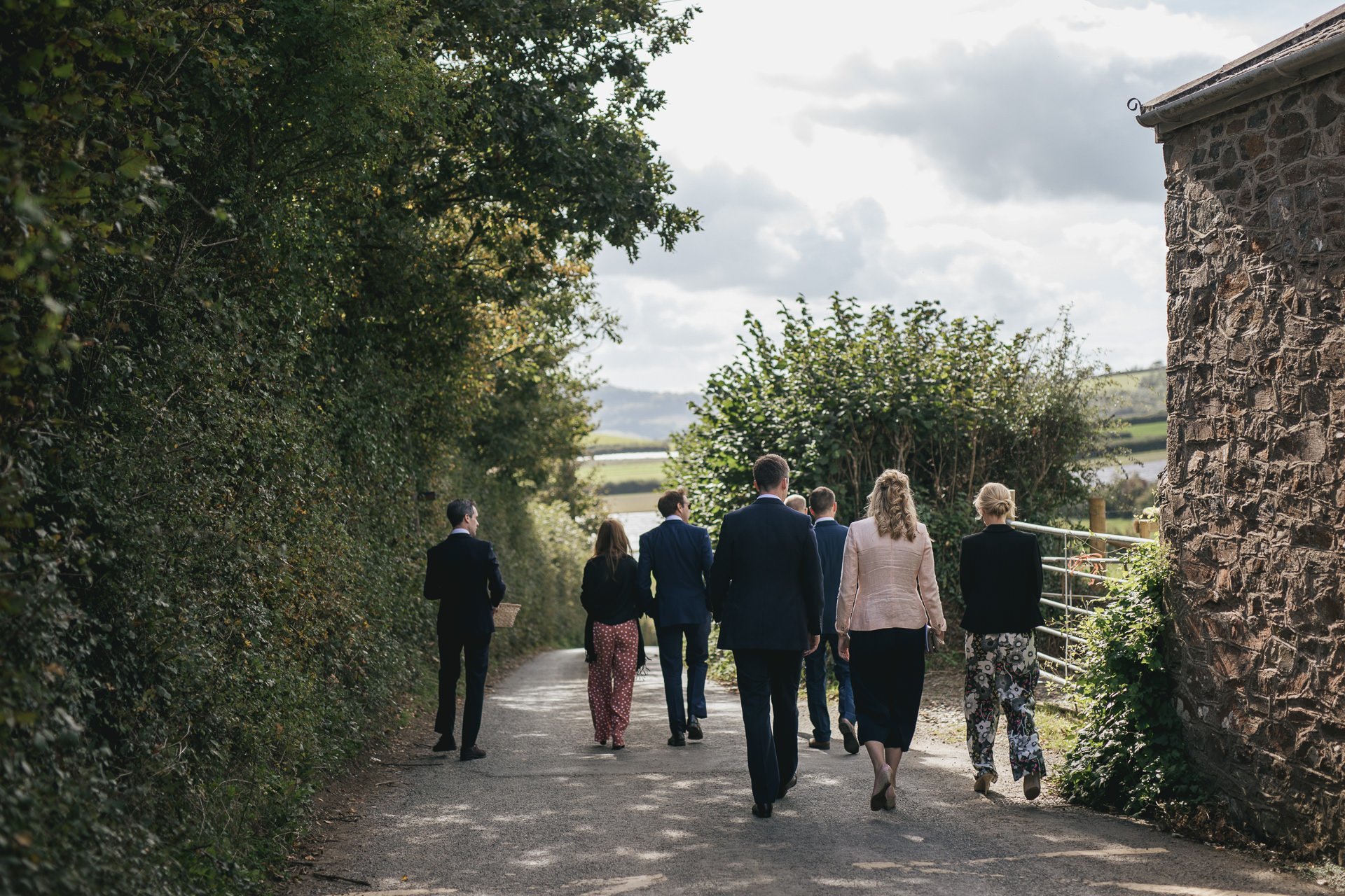 Group of wedding guests walking down a country lane