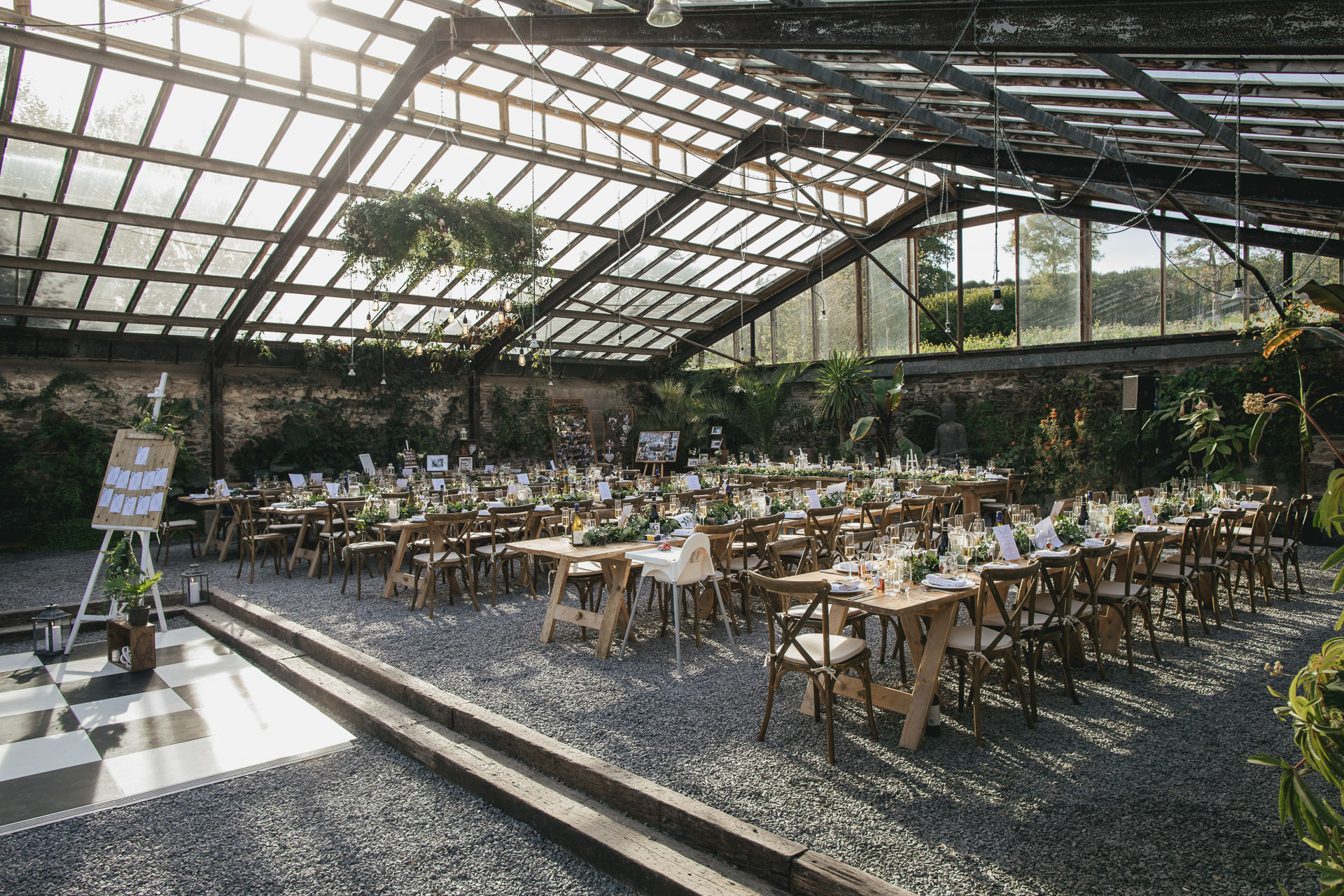 Stunning glasshouse with long tables laid and decorated for wedding