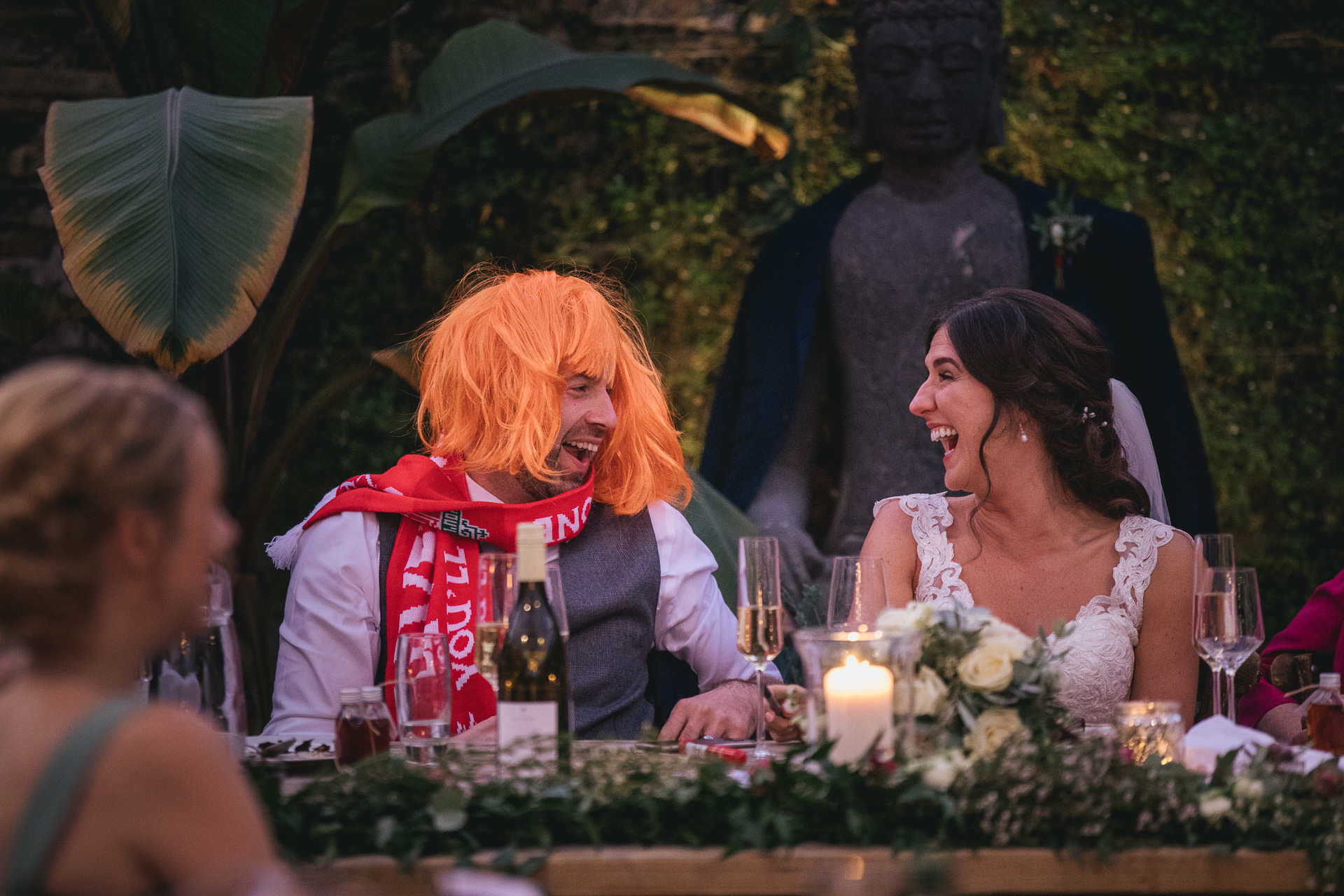 Bride laughing at groom wearing a wig