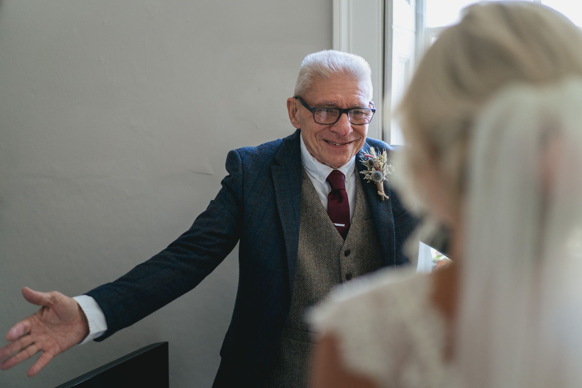 Father of the bride opening arms to greet her