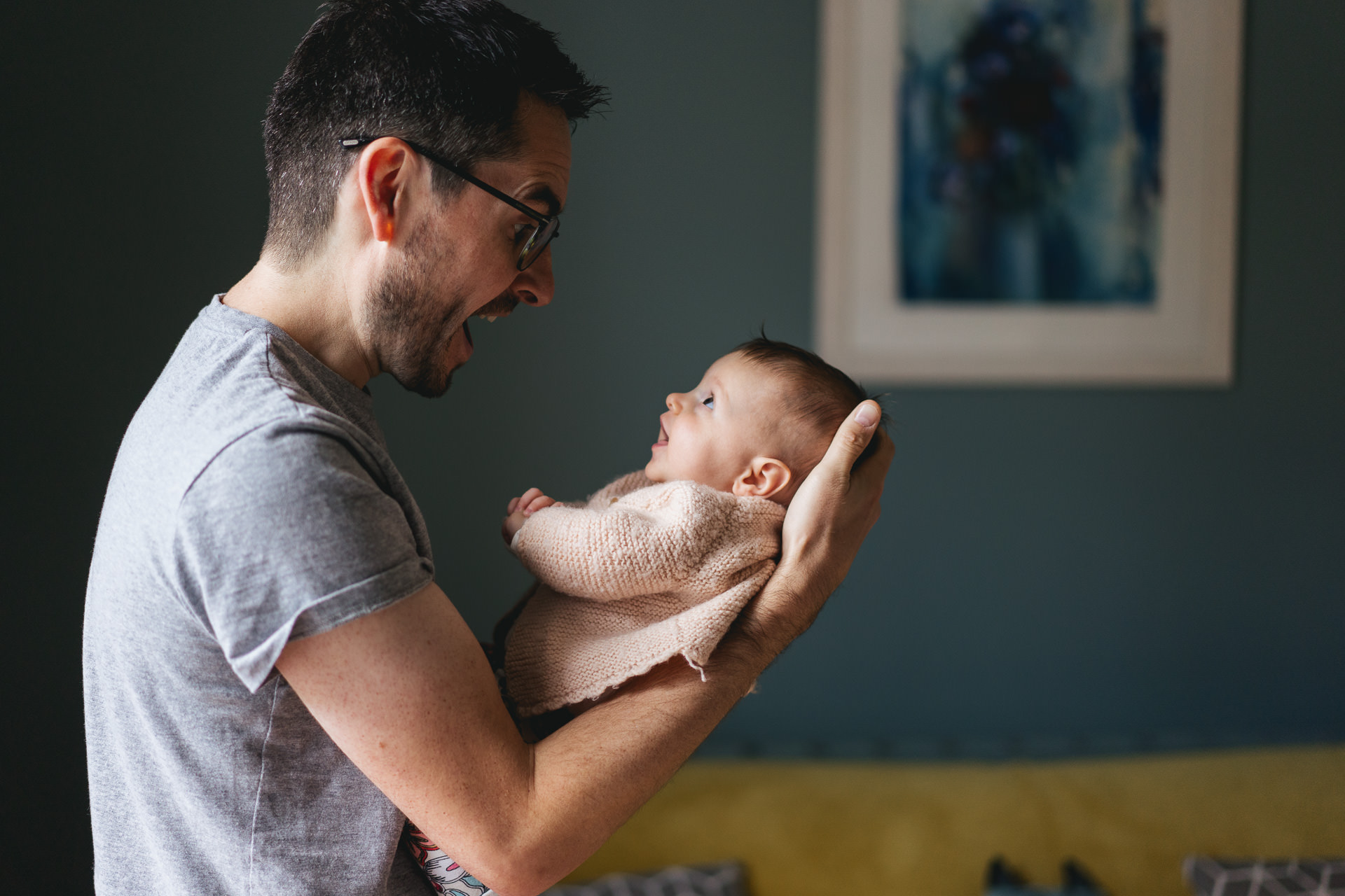 Exeter family photography: a dad holding his baby and smiling at her