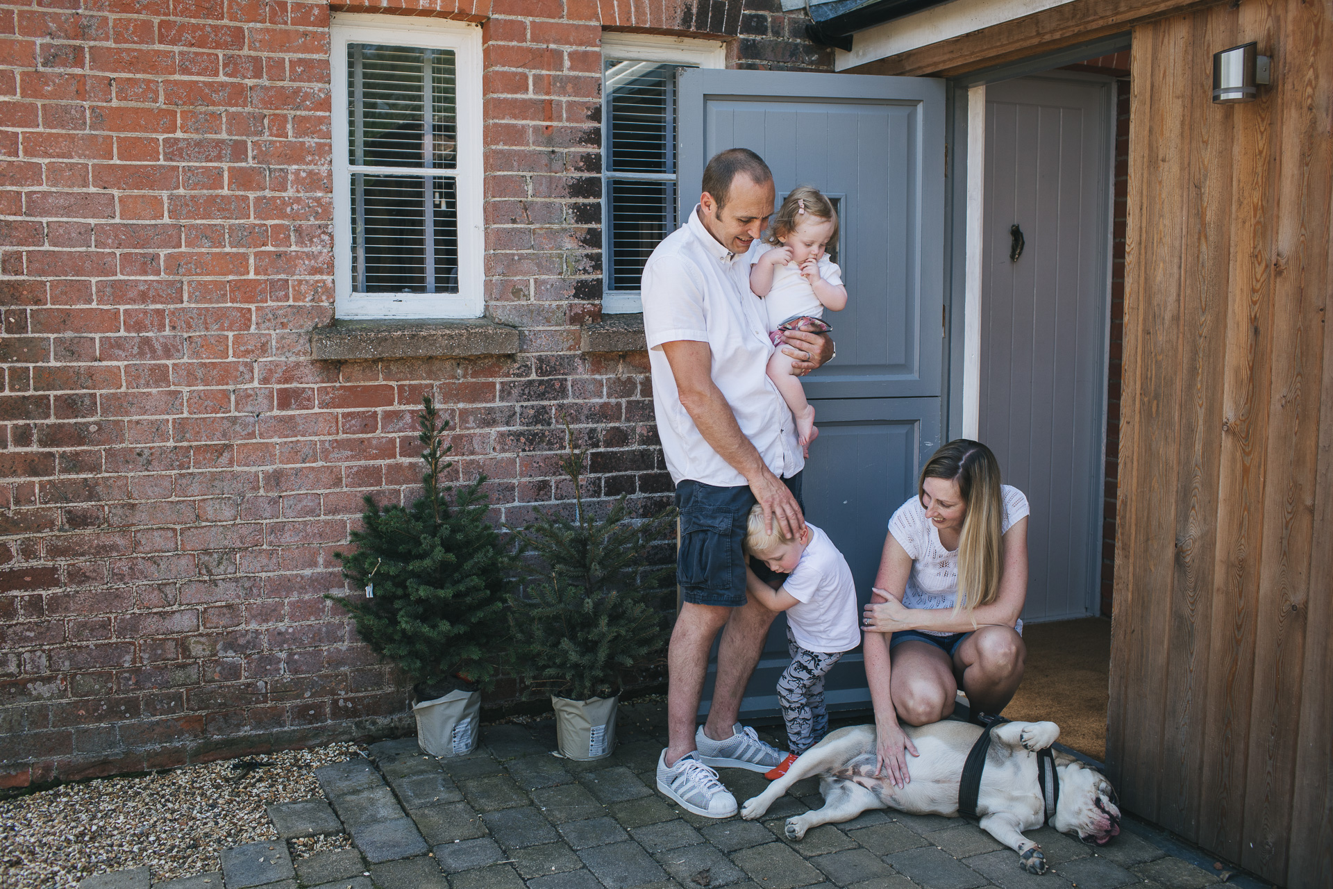A family together with a bulldog by their front door