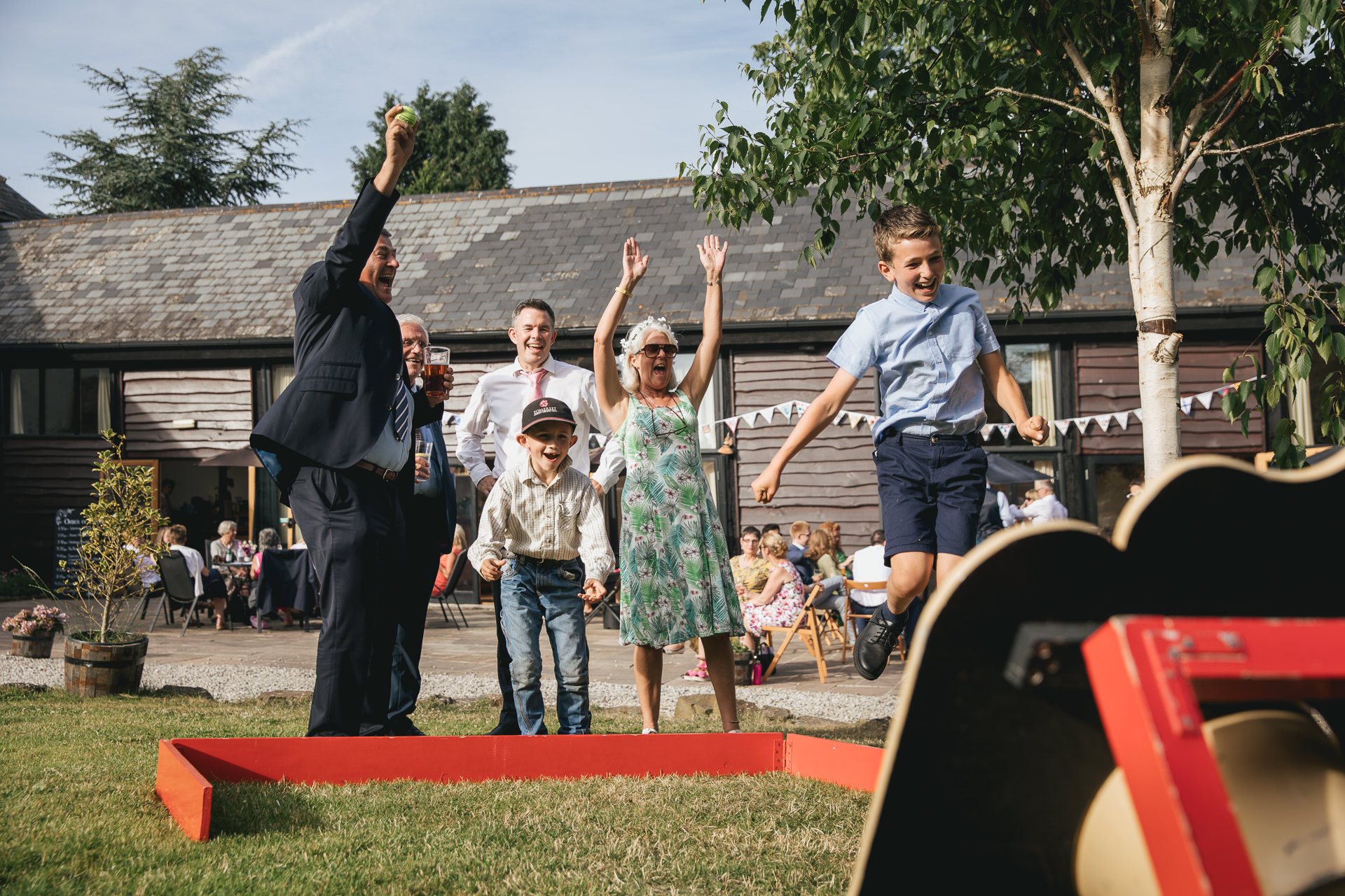 Wedding guests playing village fete games and cheering