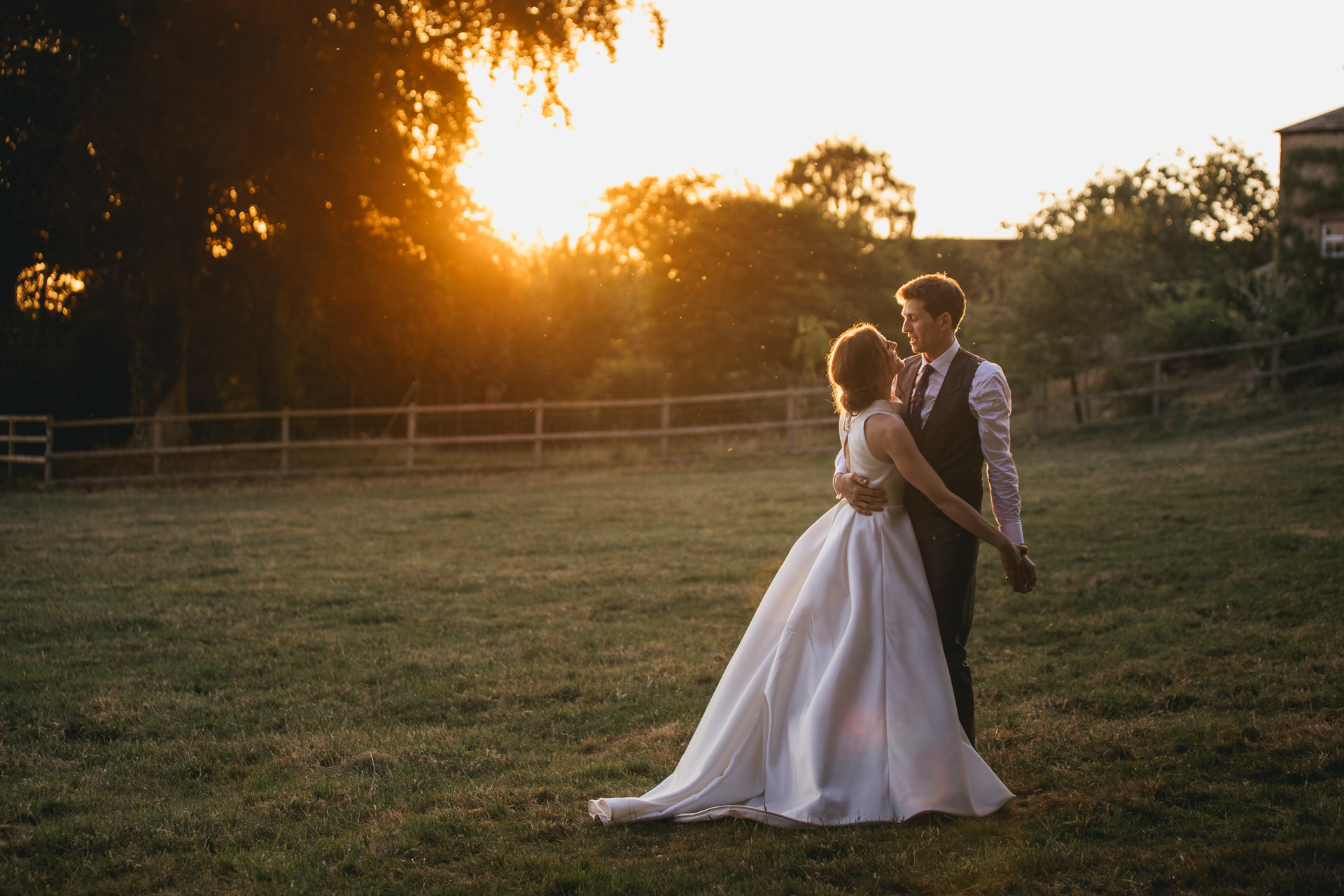 Bride and groom cuddling in sunset