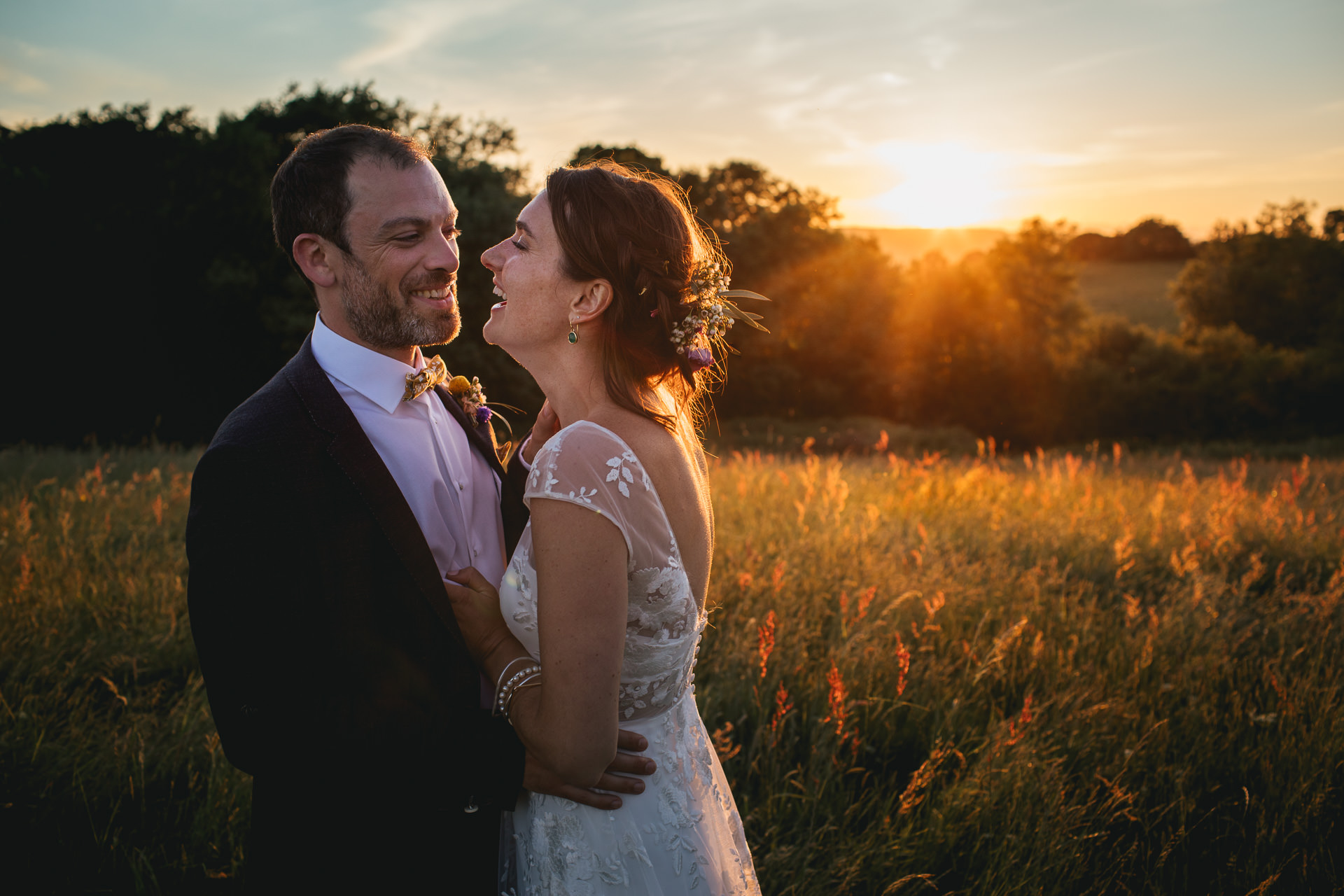 Bride and groom cuddling in sunset
