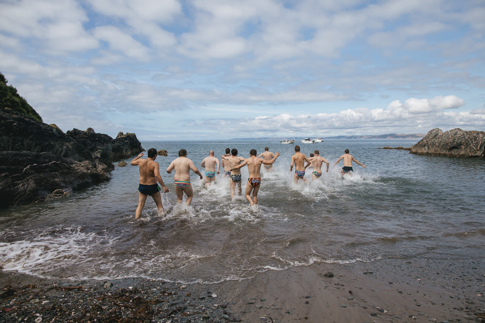 Group of men running into the sea