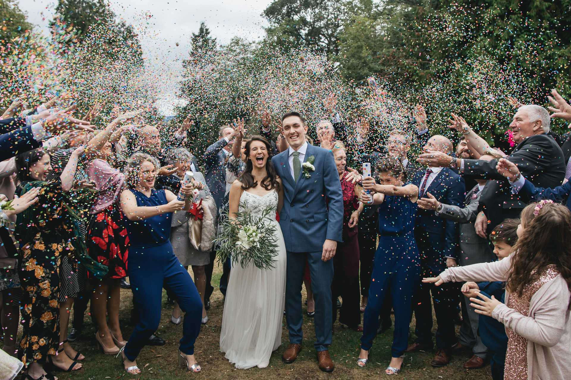 Wedding group laughing with enormous amount of confetti
