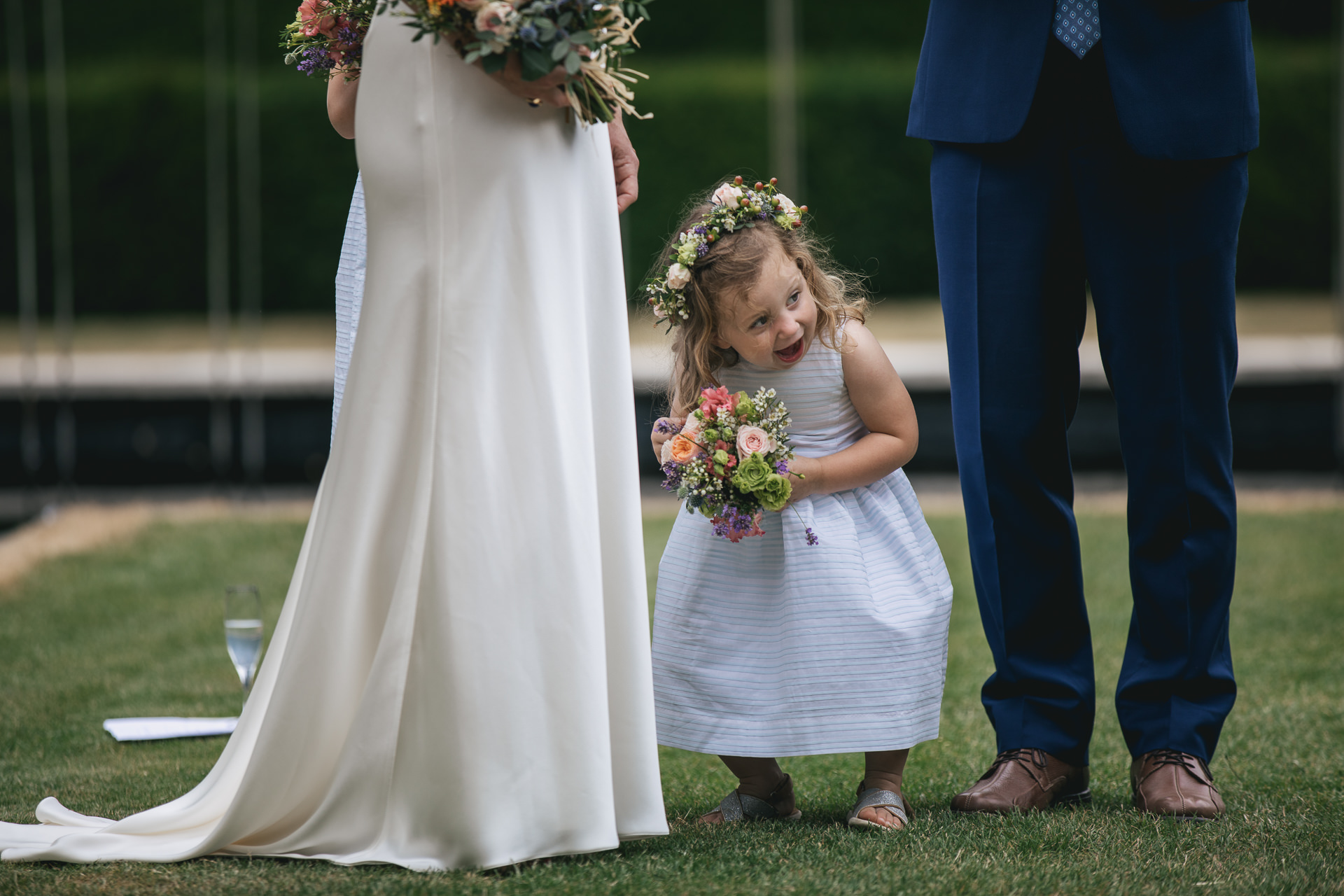Flower girl pulling faces during wedding ceremony