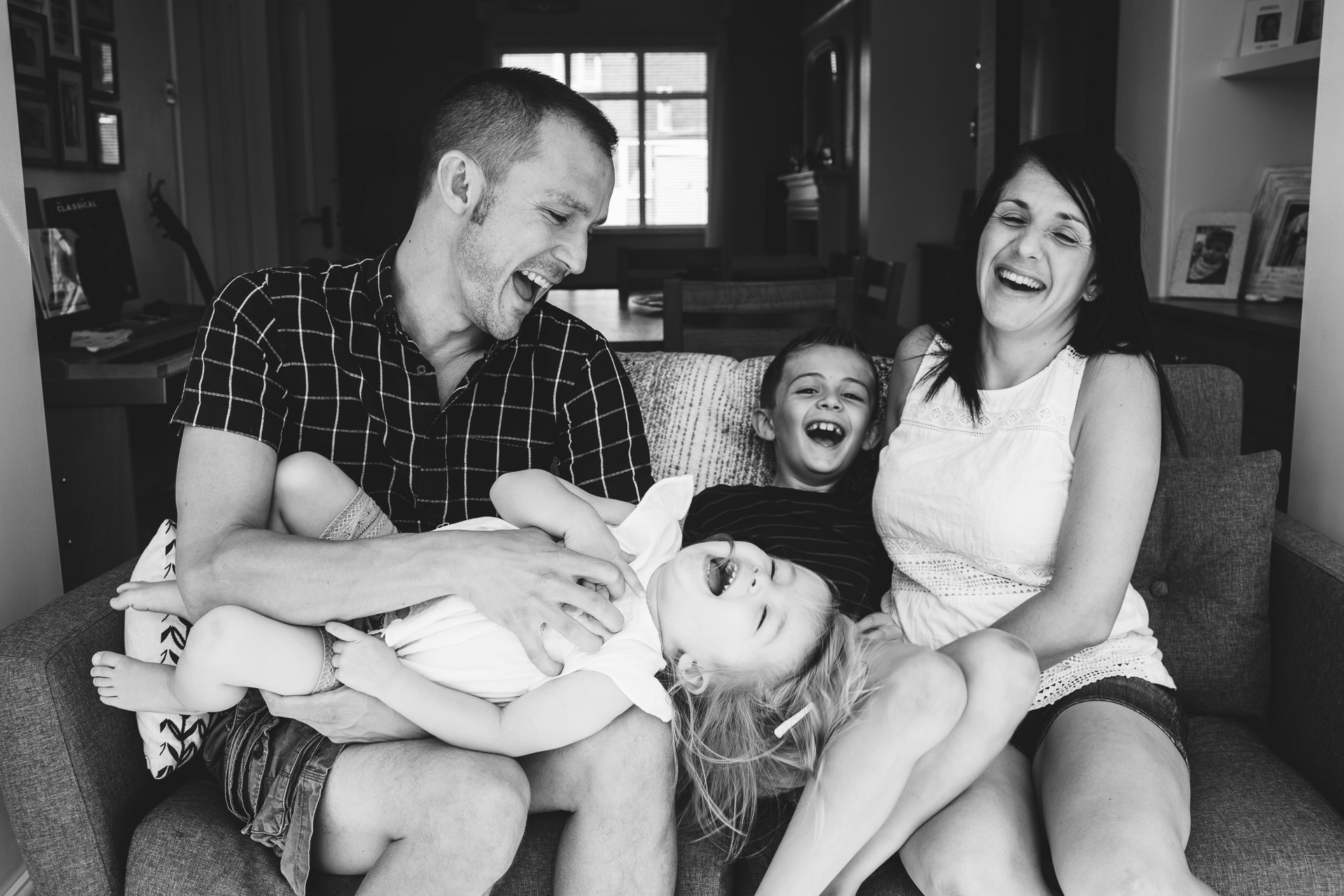 A family laughing together on a sofa
