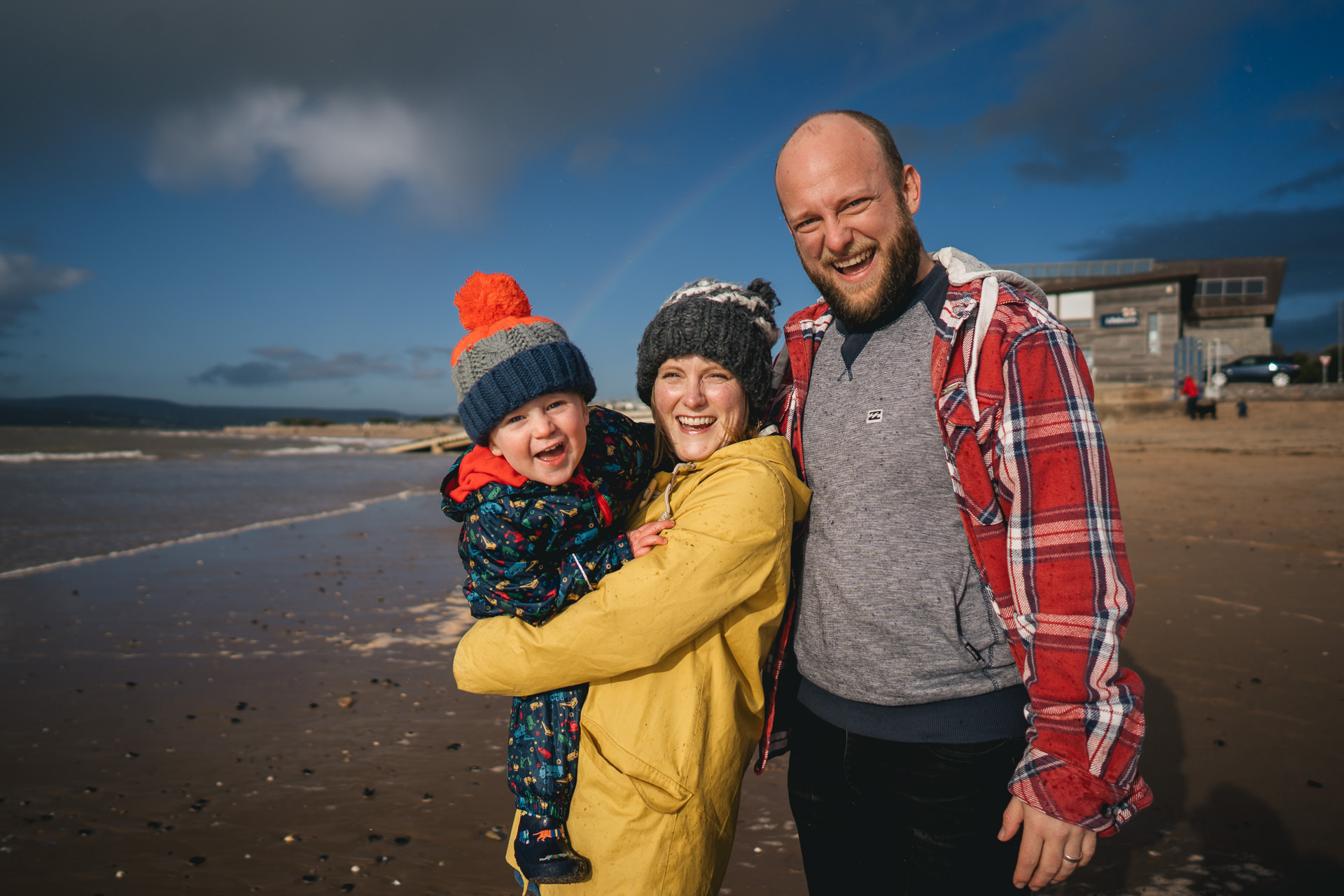 Exmouth family photography portrait on a beach with a rainbow behind