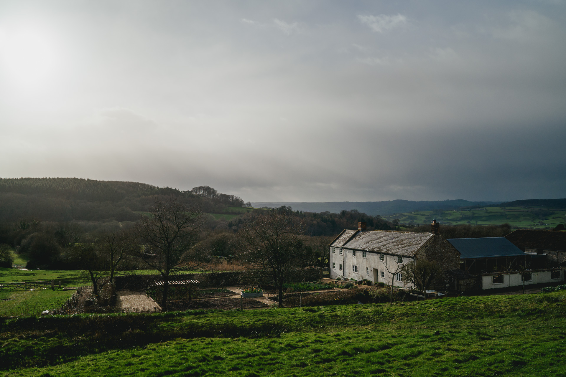 River Cottage farmhouse with showery weather surrounded by hills