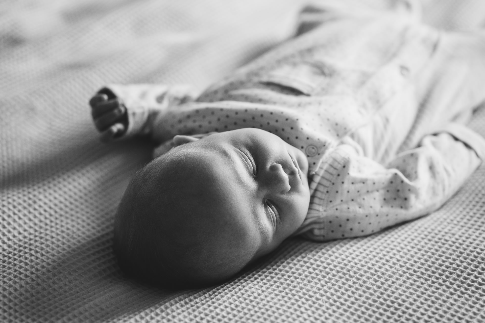 Portrait of a baby sleeping on a bed, at home in Dorset