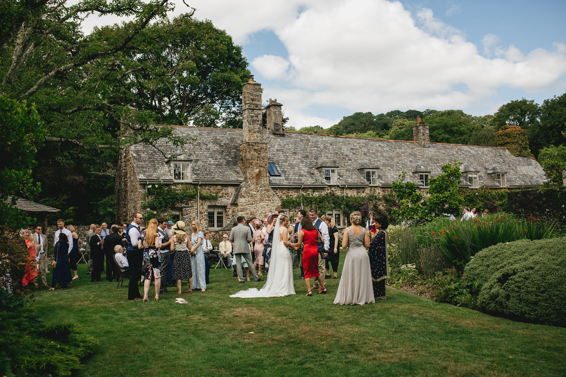 Wedding guests during drinks reception in gardens at the Great Barn