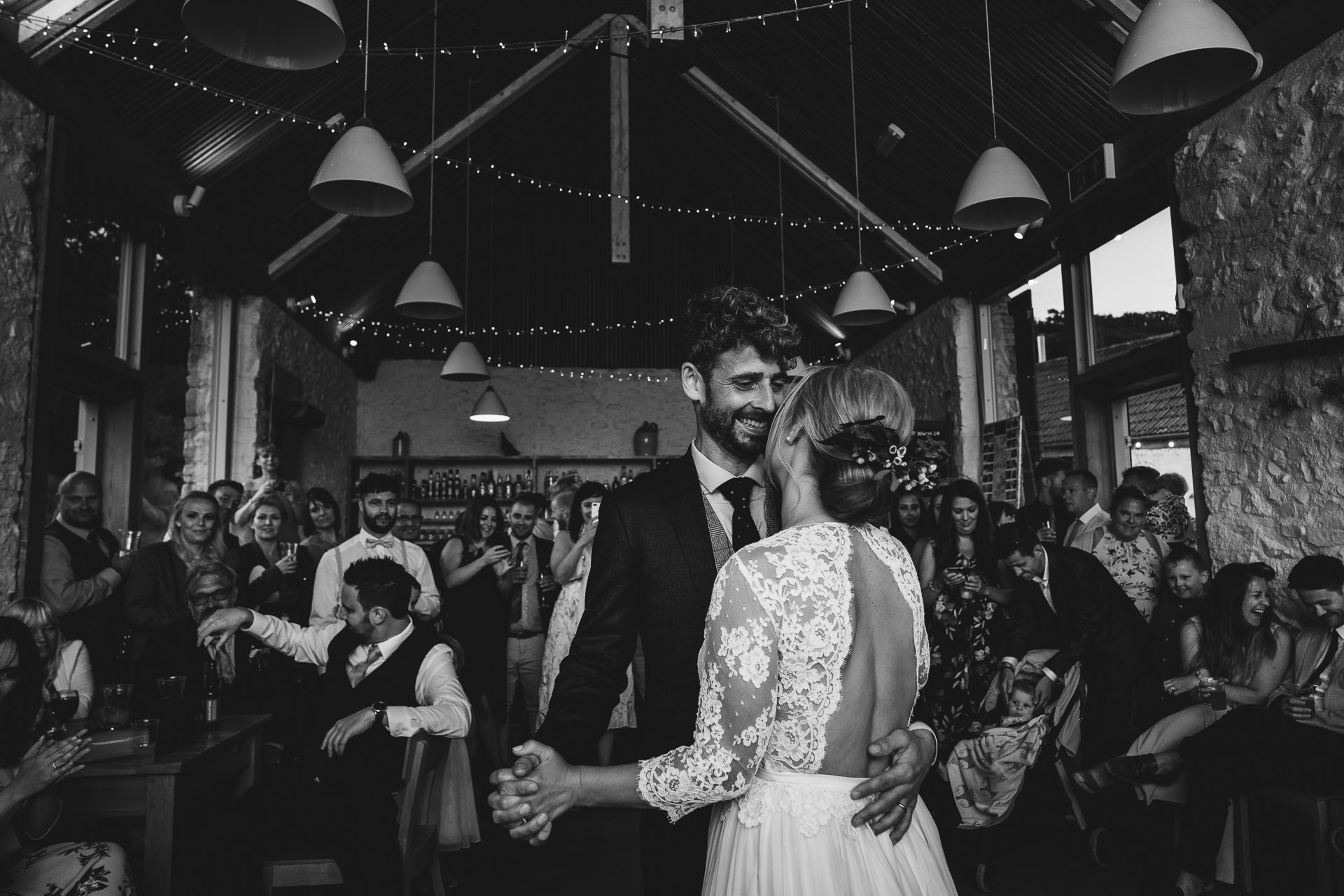 Bride and groom having their first dance in the barn