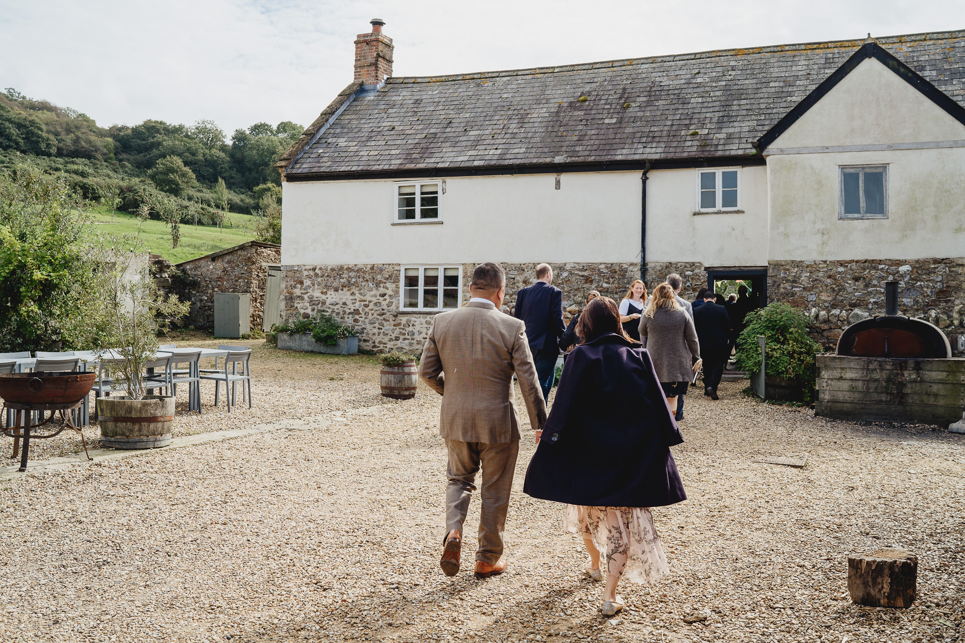 wedding guests walking towards a farmhouse