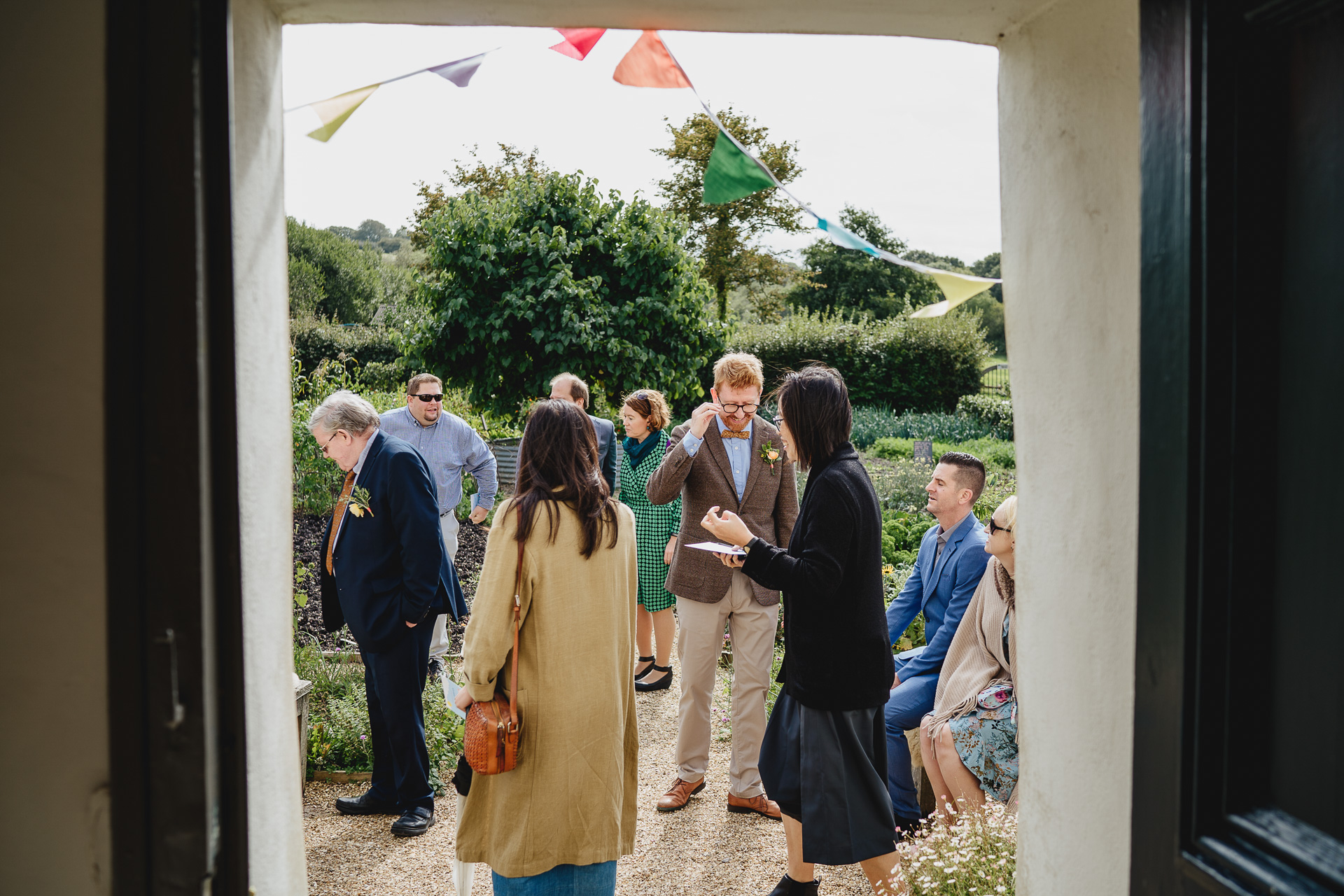 wedding guests outside in a kitchen garden, preparing for an autumn outdoor wedding ceremony