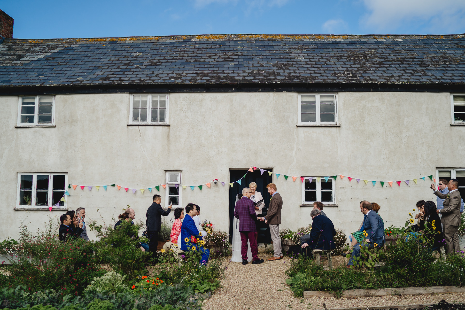 An outdoor autumn wedding ceremony in a kitchen garden, with River Cottage farmhouse behind