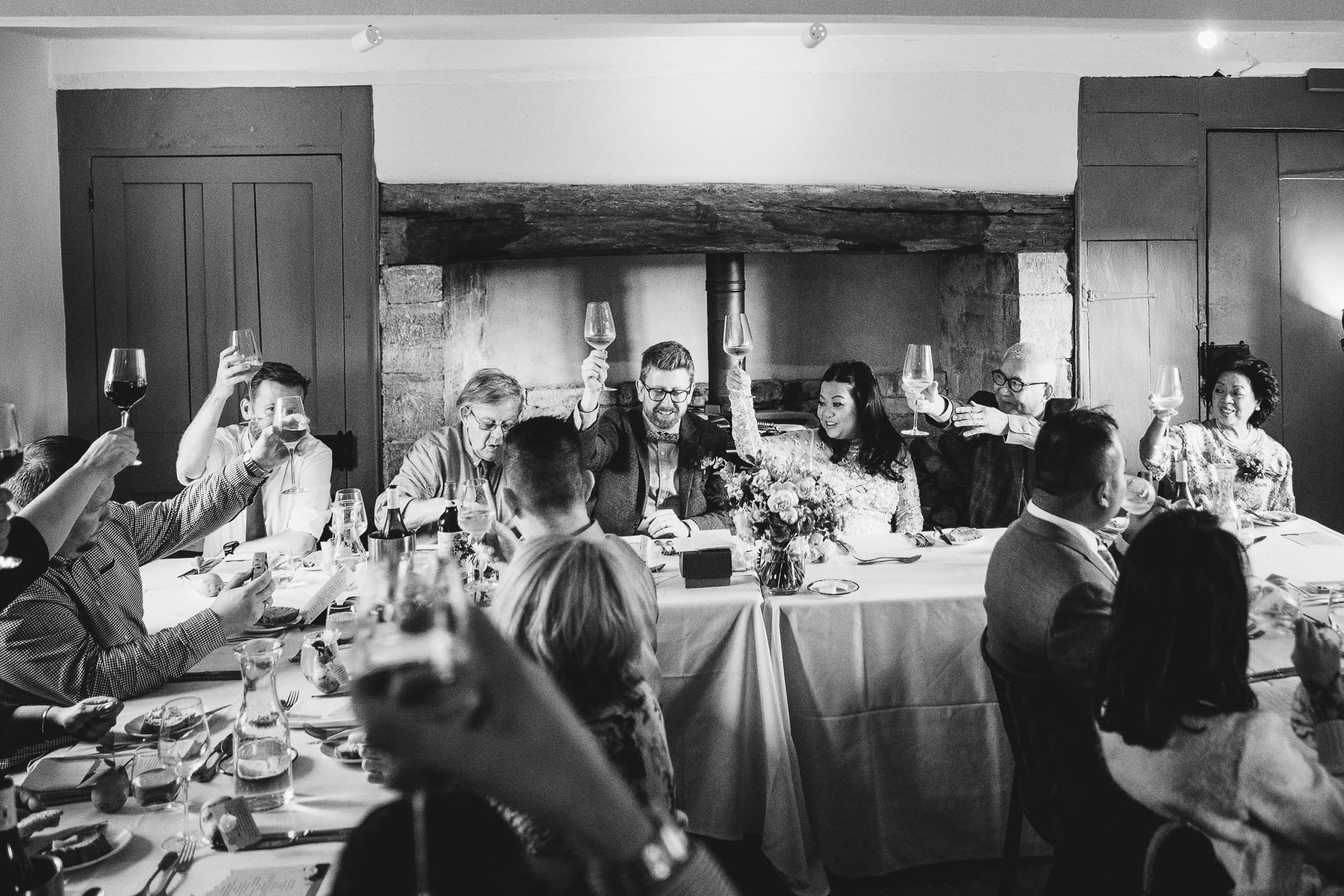 bride and groom raising glasses with guests