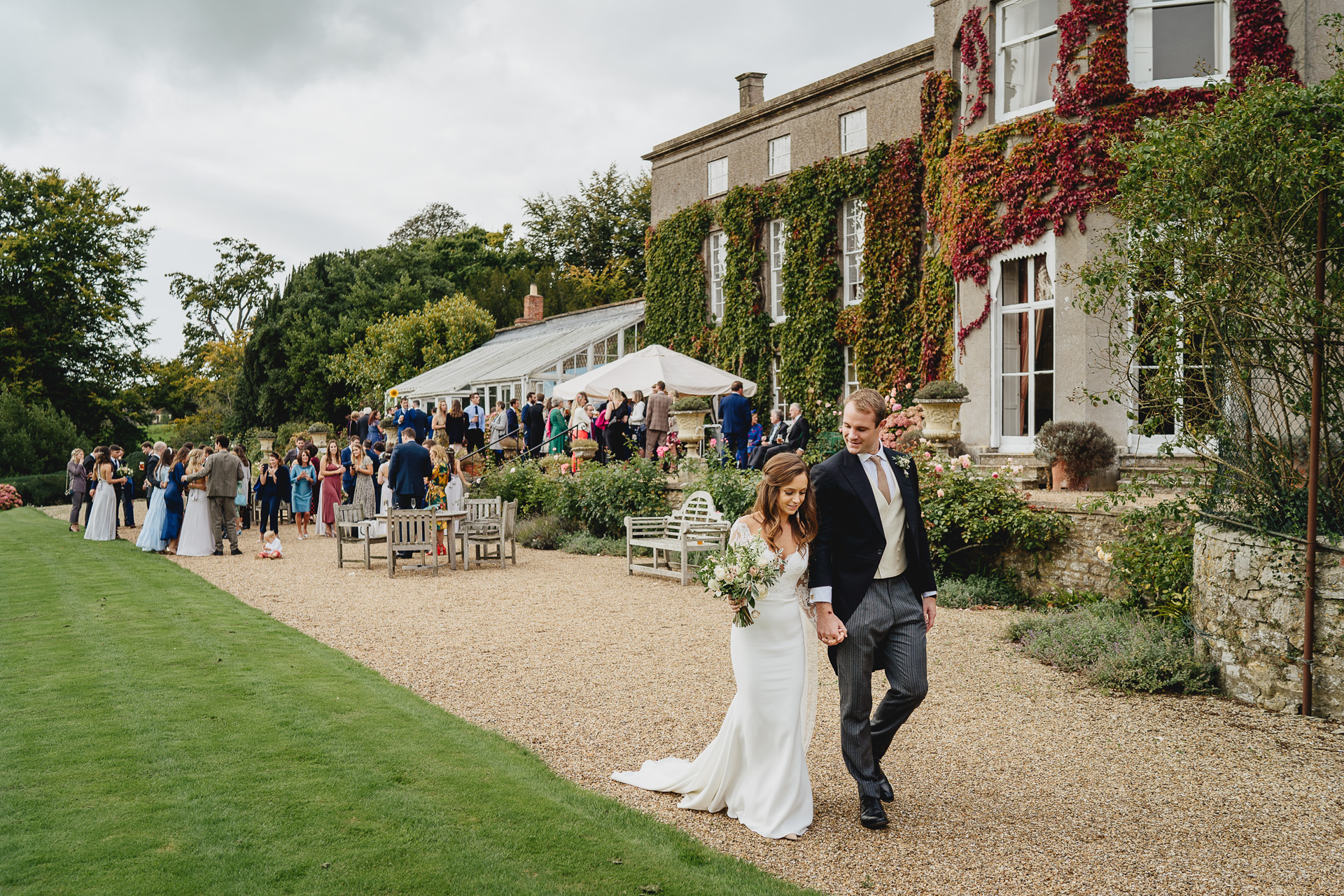 Bride and groom walking in front of guests at Pennard House