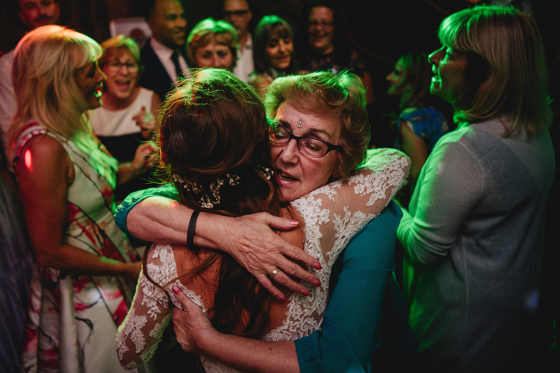 Grandmother hugging a bride on the dance floor