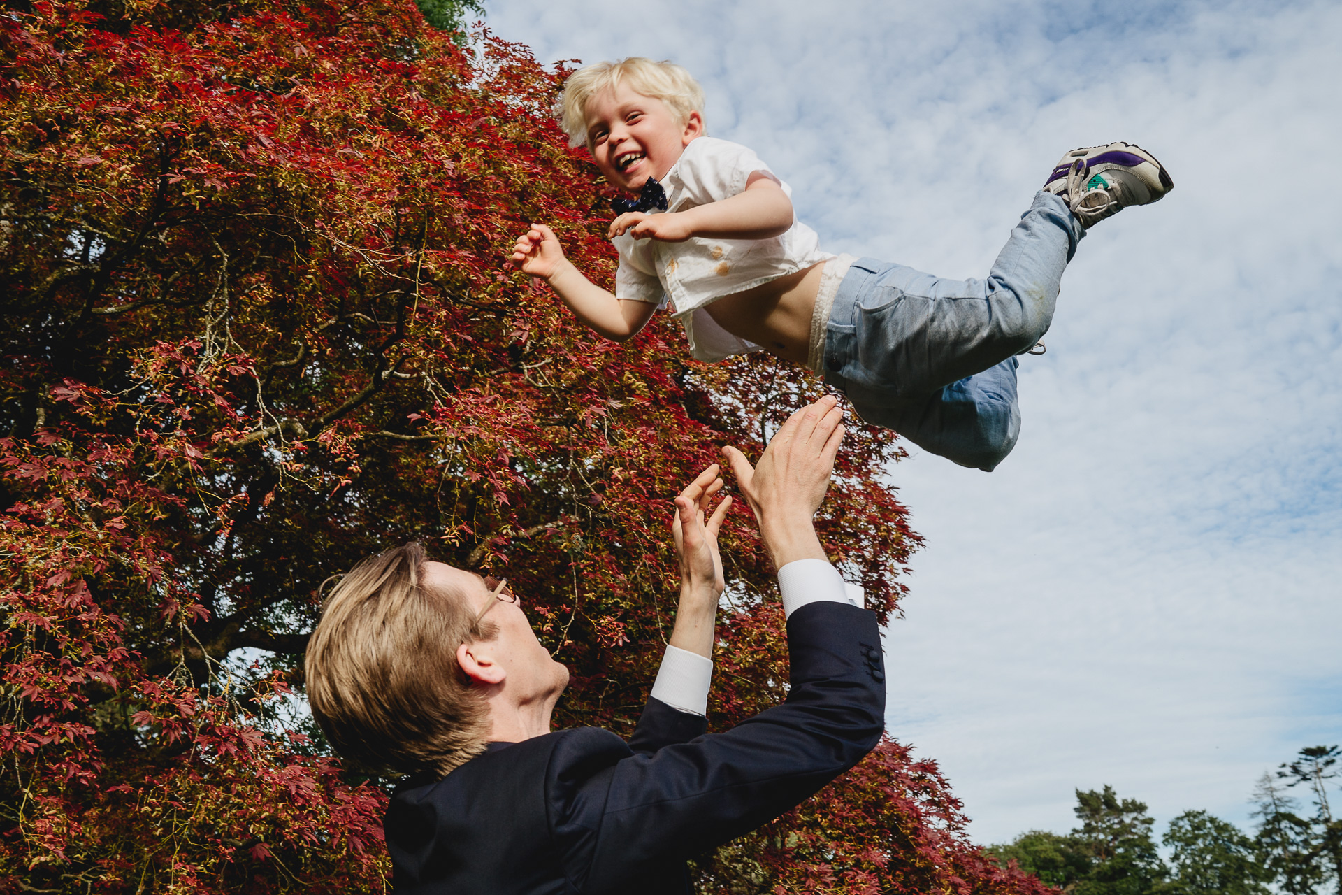 Man throwing a laughing child up in the air